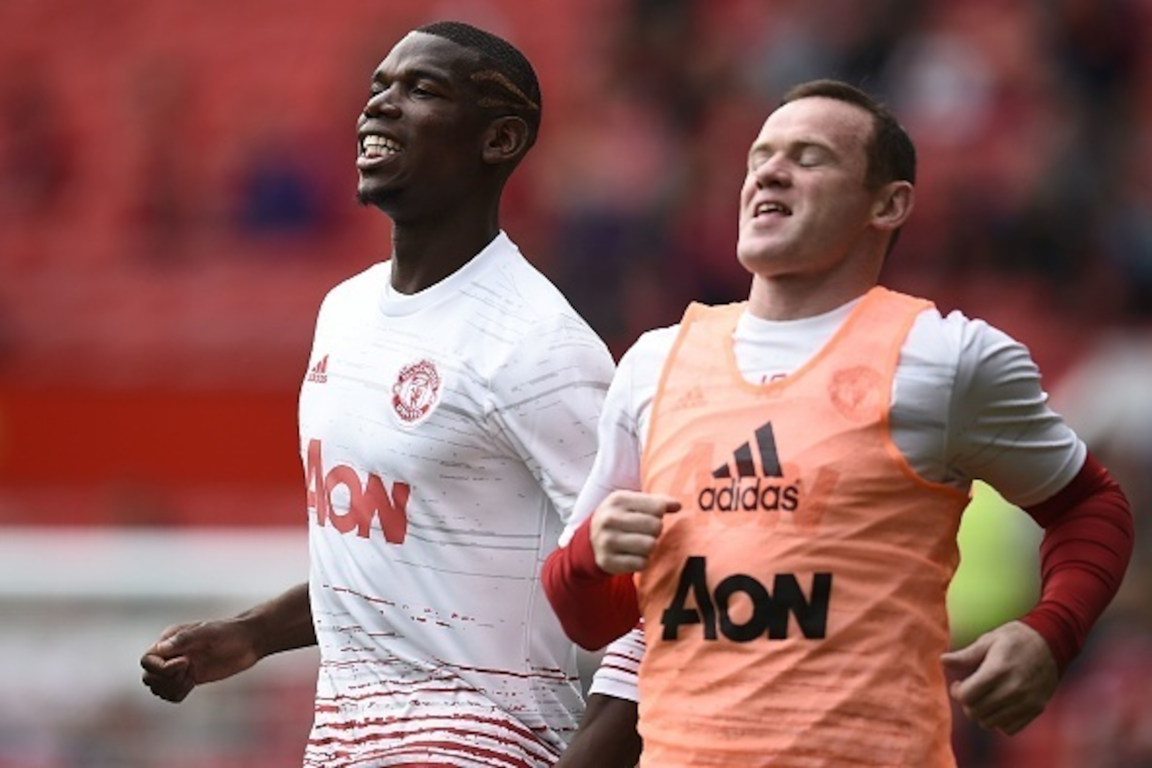 Manchester United's French midfielder Paul Pogba warms up with Manchester United's English striker Wayne Rooney (R) ahead of the English Premier League football match between Manchester United and Manchester City at Old Trafford in Manchester, north west 