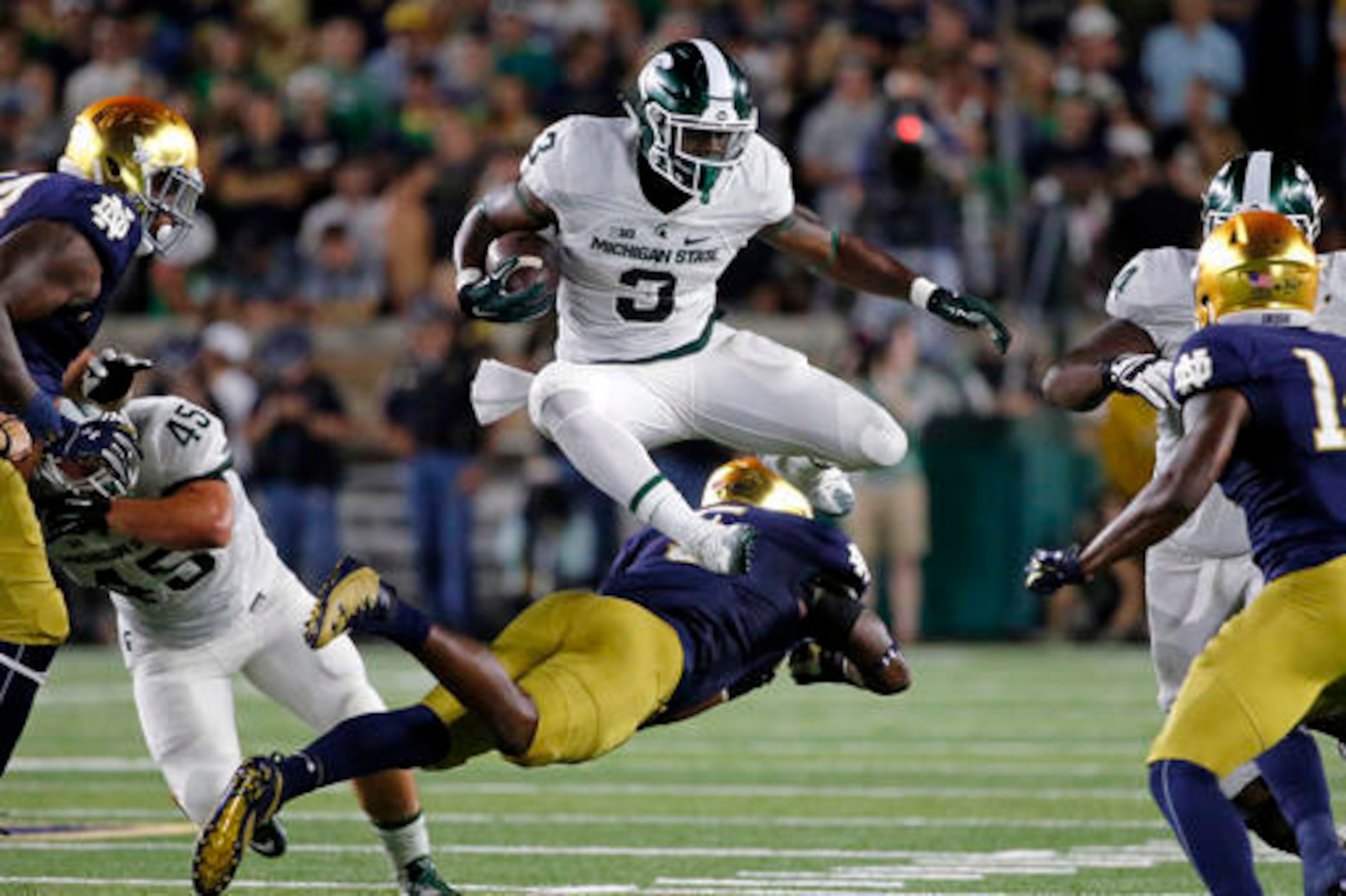 MSU running back L.J. Scott flies over a Notre Dame defender.