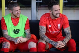 Liverpool's Spanish defender Alberto Moreno (L) and Liverpool's English striker Danny Ings (R) take their places on the substitutes bench for the English League Cup second round football match between Burton Albion and Liverpool at the Pirelli Stadium in 