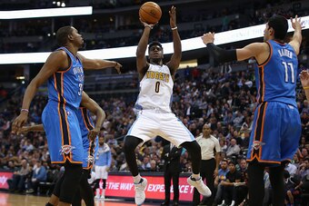 DENVER, CO - APRIL 5:  Emmanuel Mudiay #0 of the Denver Nuggets takes a shot against Kevin Durant #35 and Enes Kanter #11 of the Oklahoma City Thunder at Pepsi Center on April 5, 2016 in Denver, Colorado. The Thunder defeated the Nuggets 124-102. NOTE TO 