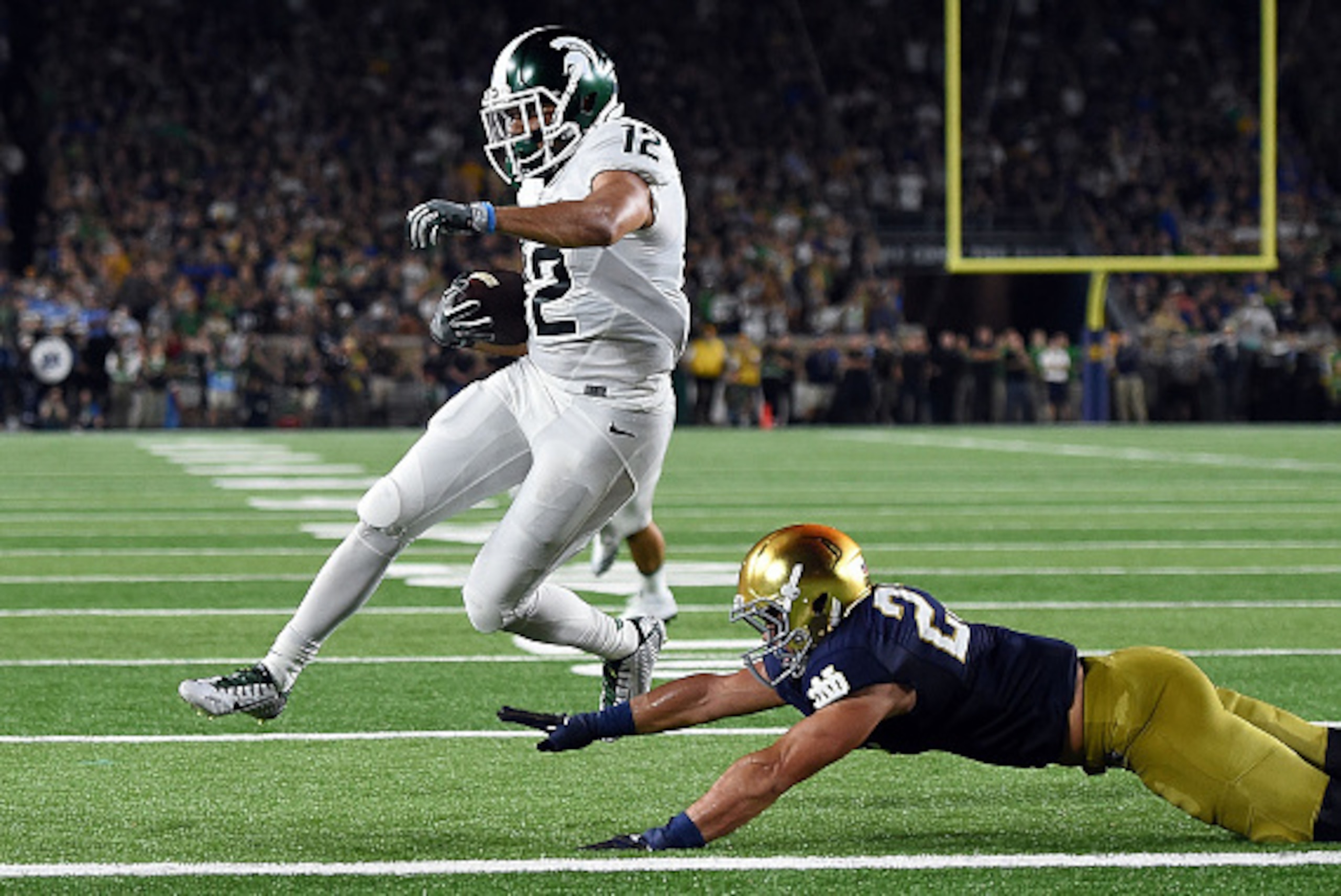 SOUTH BEND, IN - SEPTEMBER 17:  R.J. Shelton #12 of the Michigan State Spartans scores a touchdown in front of Drue Tranquill #23 of the Notre Dame Fighting Irish during the first half of a game at Notre Dame Stadium on September 17, 2016 in South Bend, I