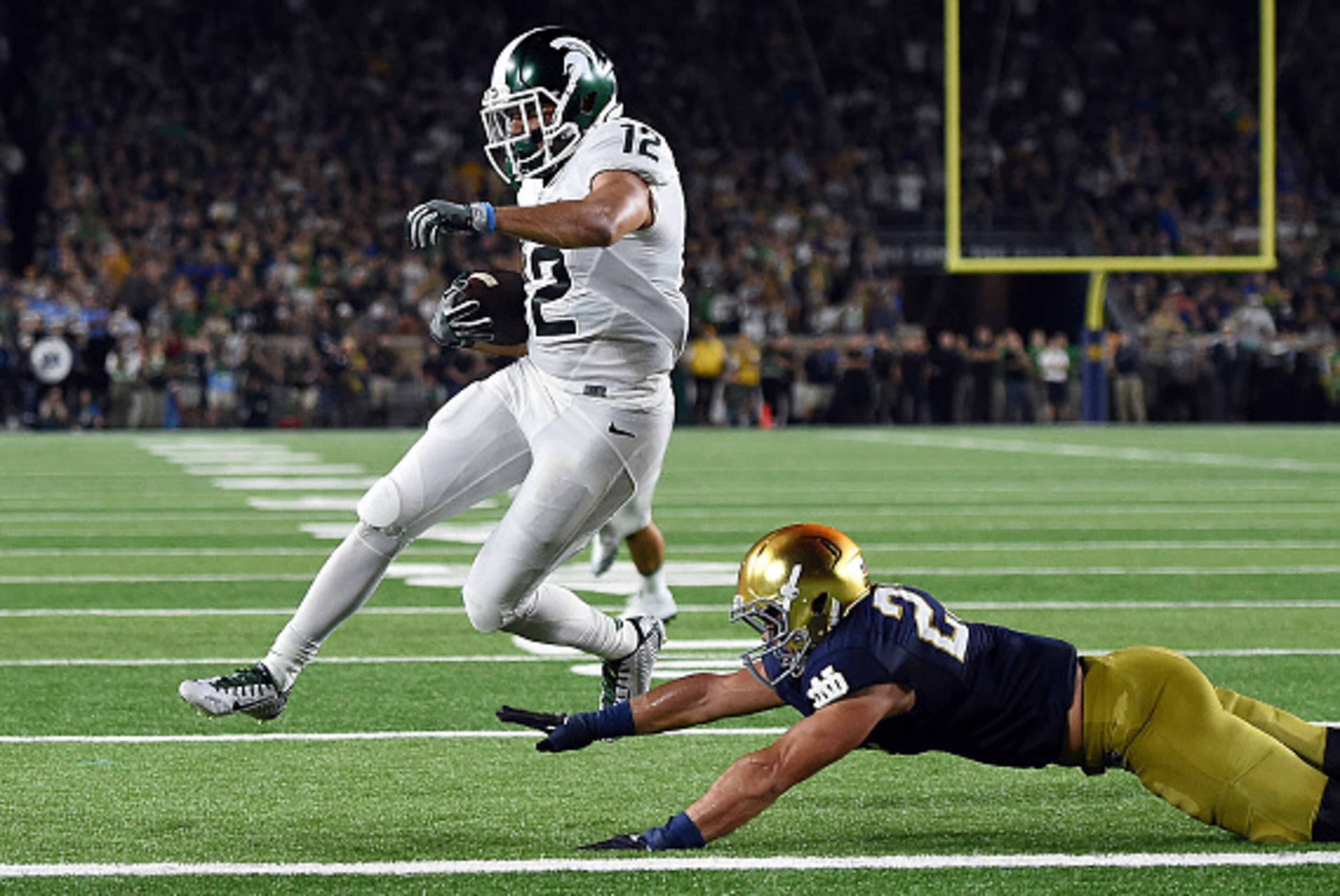 SOUTH BEND, IN - SEPTEMBER 17:  R.J. Shelton #12 of the Michigan State Spartans scores a touchdown in front of Drue Tranquill #23 of the Notre Dame Fighting Irish during the first half of a game at Notre Dame Stadium on September 17, 2016 in South Bend, I