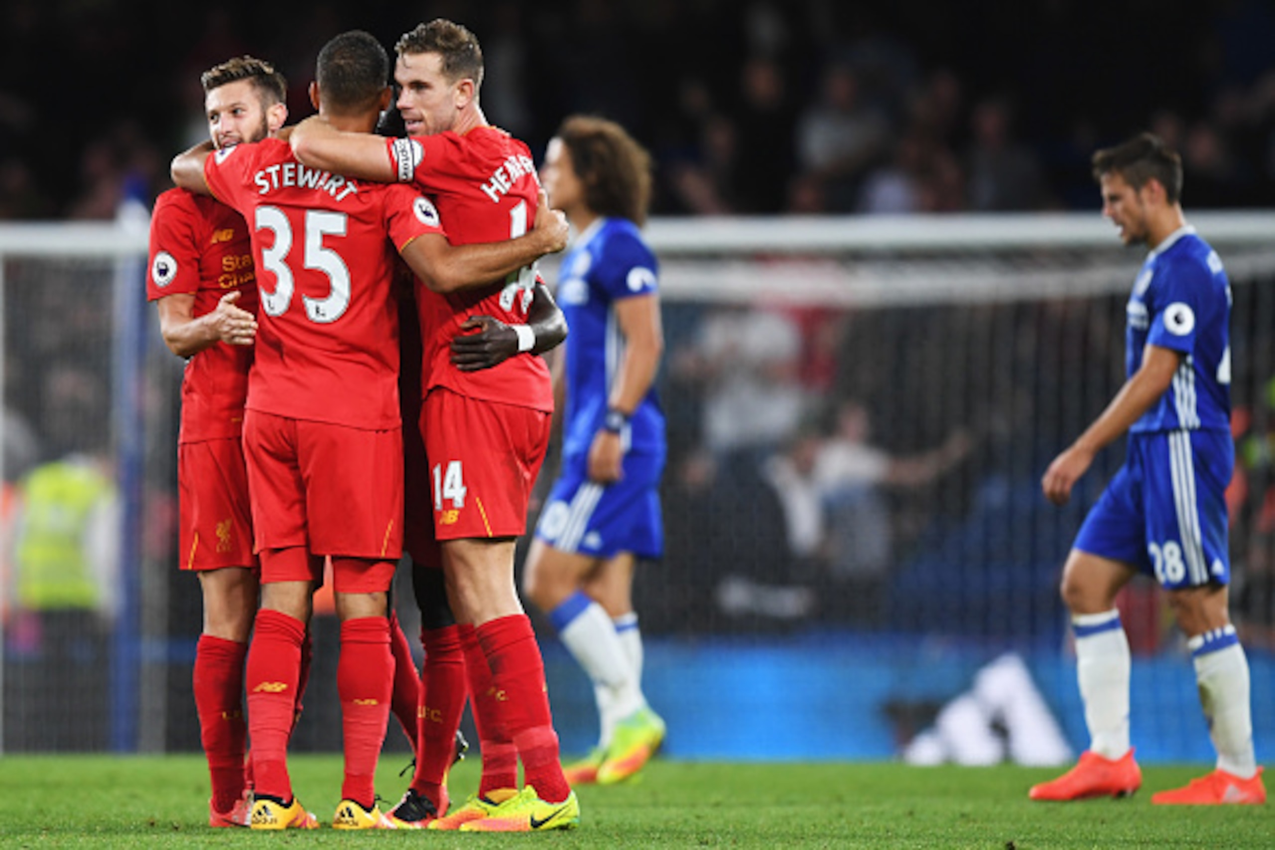 LONDON, ENGLAND - SEPTEMBER 16: Winning goalscorer Jordan Henderson of Liverpool (14) celebrates victory with Adam Lallana (L) and Kevin Stewart after the Premier League match between Chelsea and Liverpool at Stamford Bridge on September 16, 2016 in Lond LONDON, ENGLAND - SEPTEMBER 16: Winning goalscorer Jordan Henderson of Liverpool (14) celebrates victory with Adam Lallana (L) and Kevin Stewart after the Premier League match between Chelsea and Liverpool at Stamford Bridge on September 16, 2016 in Lond