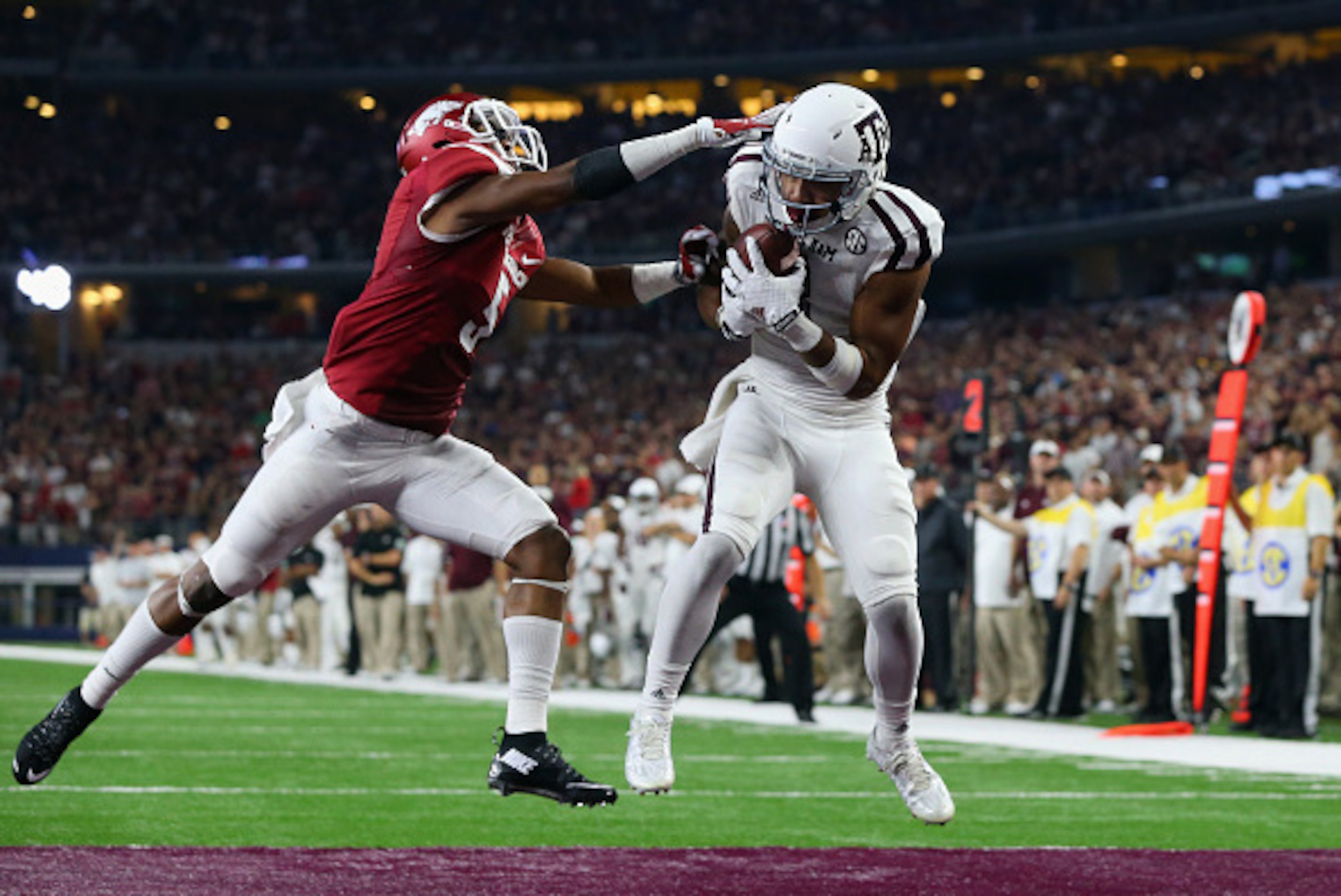 ARLINGTON, TX - SEPTEMBER 26:  Christian Kirk #3 of the Texas A&M Aggies makes the game winning touchdown against Henre' Toliver #5 of the Arkansas Razorbacks in overtime during the Southwest Classic at AT&T Stadium on September 26, 2015 in Arlington, Tex
