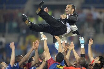 Barcelona´s coach Josep Guardiola (top) celebrates with players after the trophy ceremony  of the final of the UEFA football Champions League on May 27, 2009 at the Olympic Stadium in Rome. Barcelona defeated Manchester United 2-0 to win the Cup.     AFP 