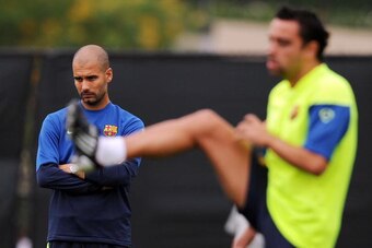 Barcelona FC head coach Josep Guardiola (L) looks on as midfielder Xavi Hernandez streches during a training session at UCLA in Los Angeles on July 30, 2009. Barcelona will face the Los Angeles Galaxy on August 1 in Pasadena, California.  AFP PHOTO / GABR