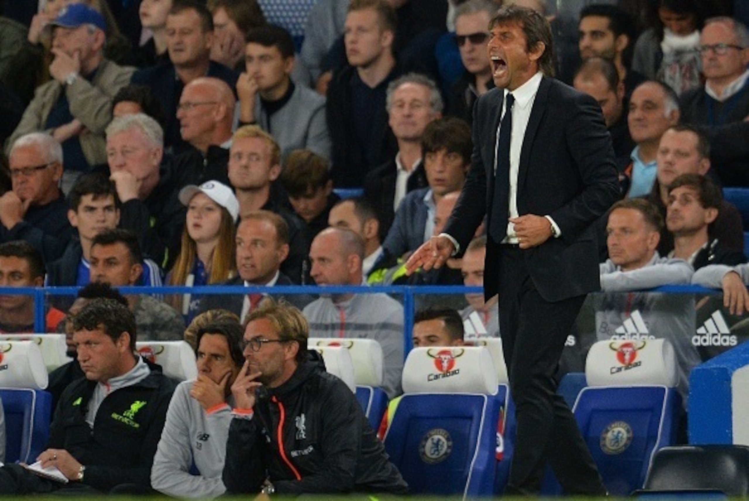 Liverpool's German manager Jurgen Klopp (L) and Chelsea's Italian head coach Antonio Conte watch thier players during the English Premier League football match between Chelsea and Liverpool at Stamford Bridge in London on September 16, 2016. / AFP / GLYN 