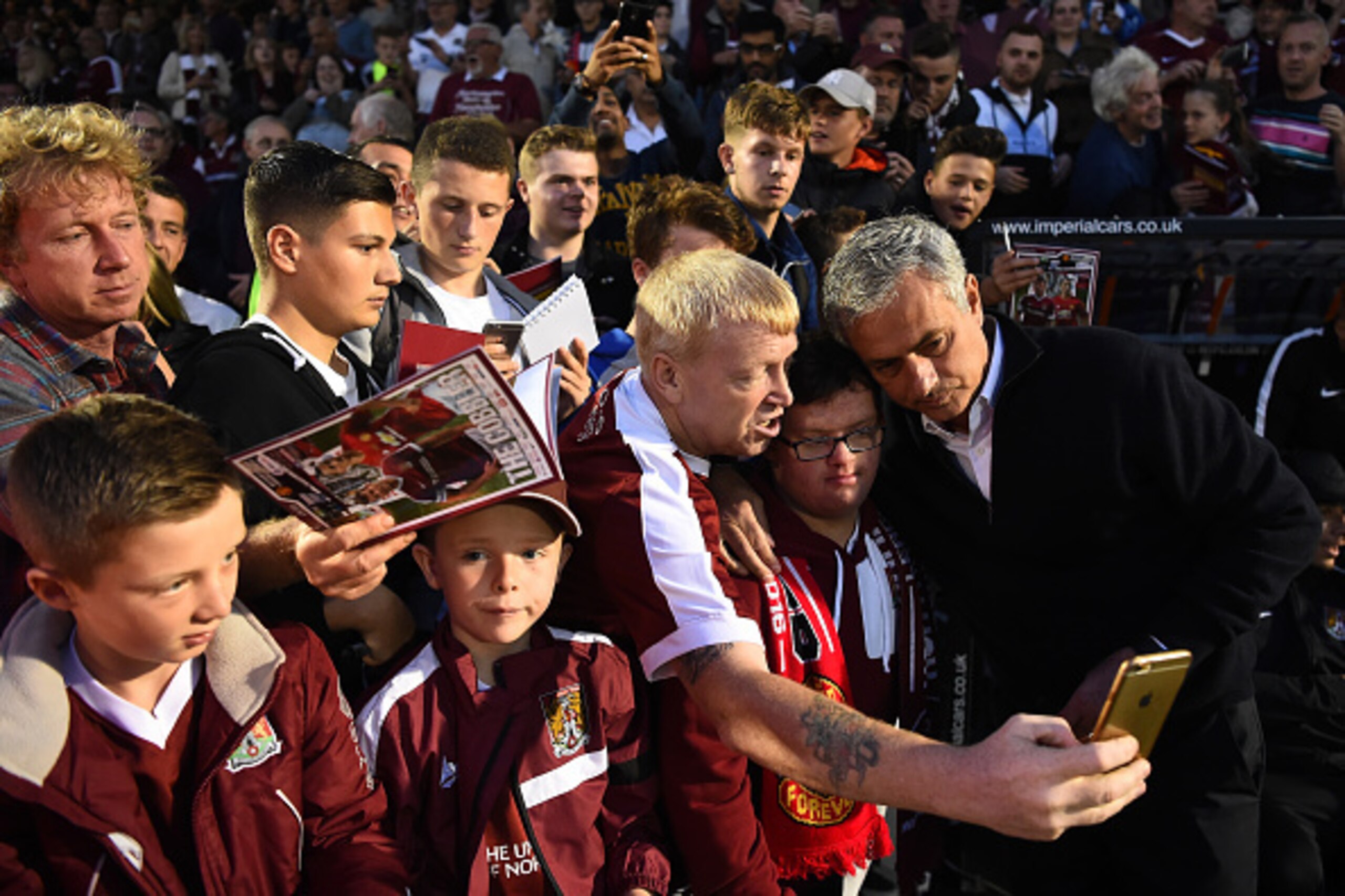 NORTHAMPTON, ENGLAND - SEPTEMBER 21:  Jose Mourinho manager of Manchester United poses for selfie photographs with fans prior to the EFL Cup Third Round match between Northampton Town and Manchester United at Sixfields on September 21, 2016 in Northampton