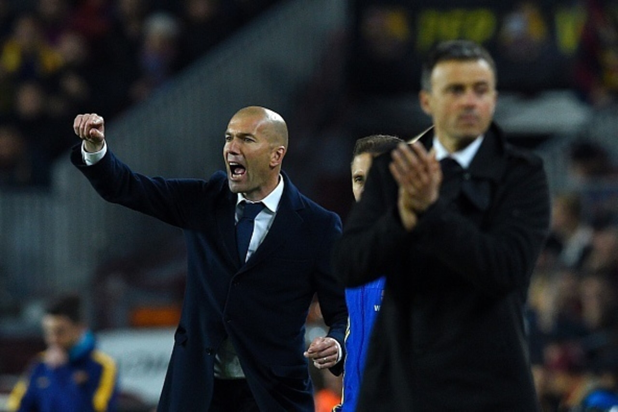 Real Madrid's French coach Zinedine Zidane (L) gives instructions to players during the Spanish league 'Clasico' football match FC Barcelona vs Real Madrid CF at the Camp Nou stadium in Barcelona on April 2, 2016. / AFP / LLUIS GENE        (Photo credit s