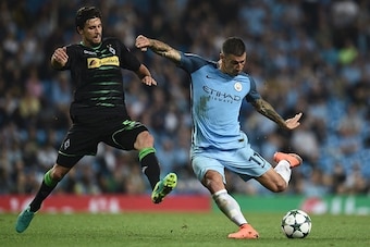 Manchester City's Serbian defender Aleksandar Kolarov (R) takes a shot during the UEFA Champions League group C football match between Manchester City and Borussia Monchengladbach at the Etihad stadium in Manchester, northwest England, on September 14, 20