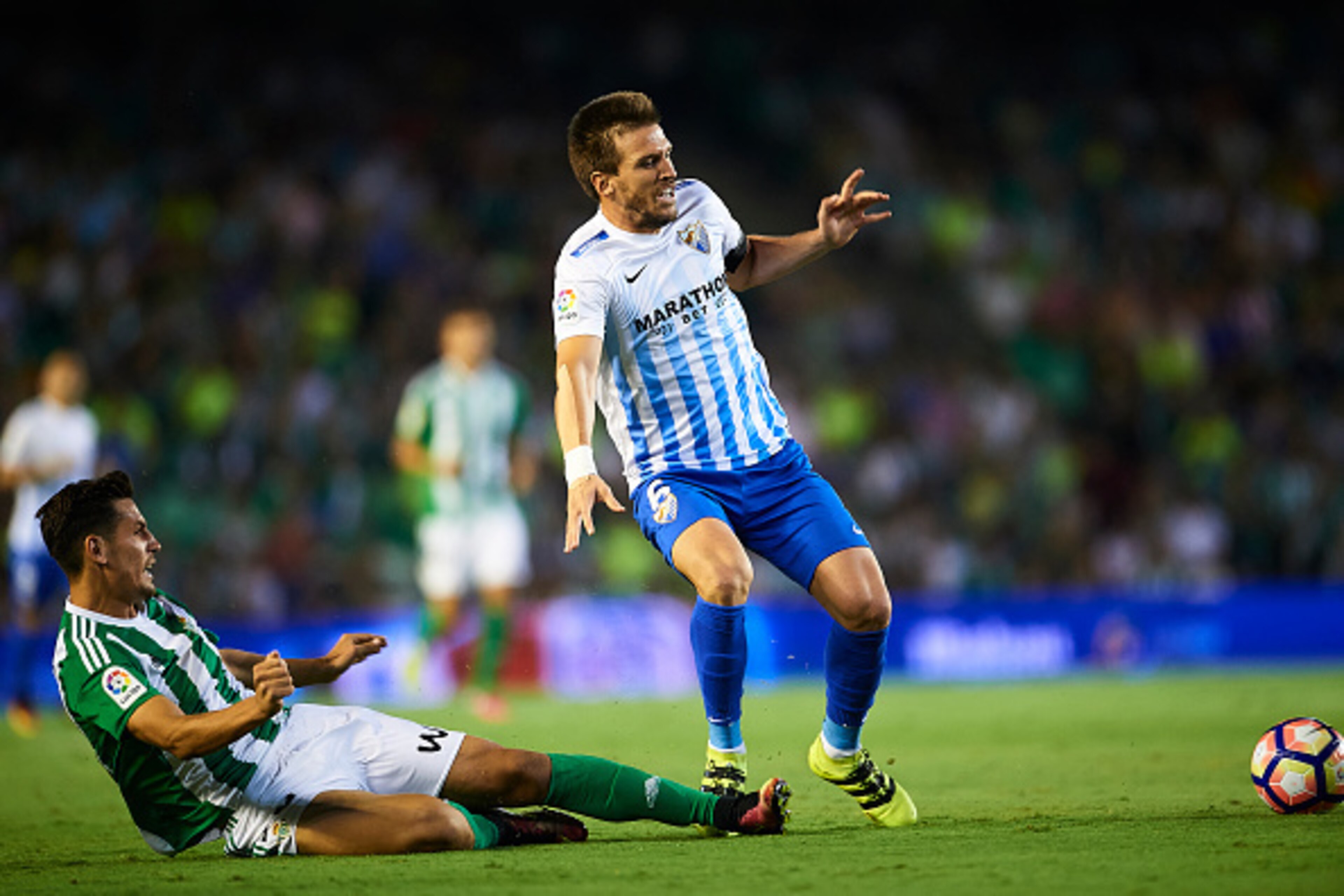 SEVILLE, SPAIN - SEPTEMBER 23: Alex Alegria of Real Betis Balompie (L) competes for the ball with Diego Llorente of Malaga CF (R)  during the match between Real Betis Balompie vs Malaga CF as part of La Liga at Benito Villamarin stadium on September 23, 2