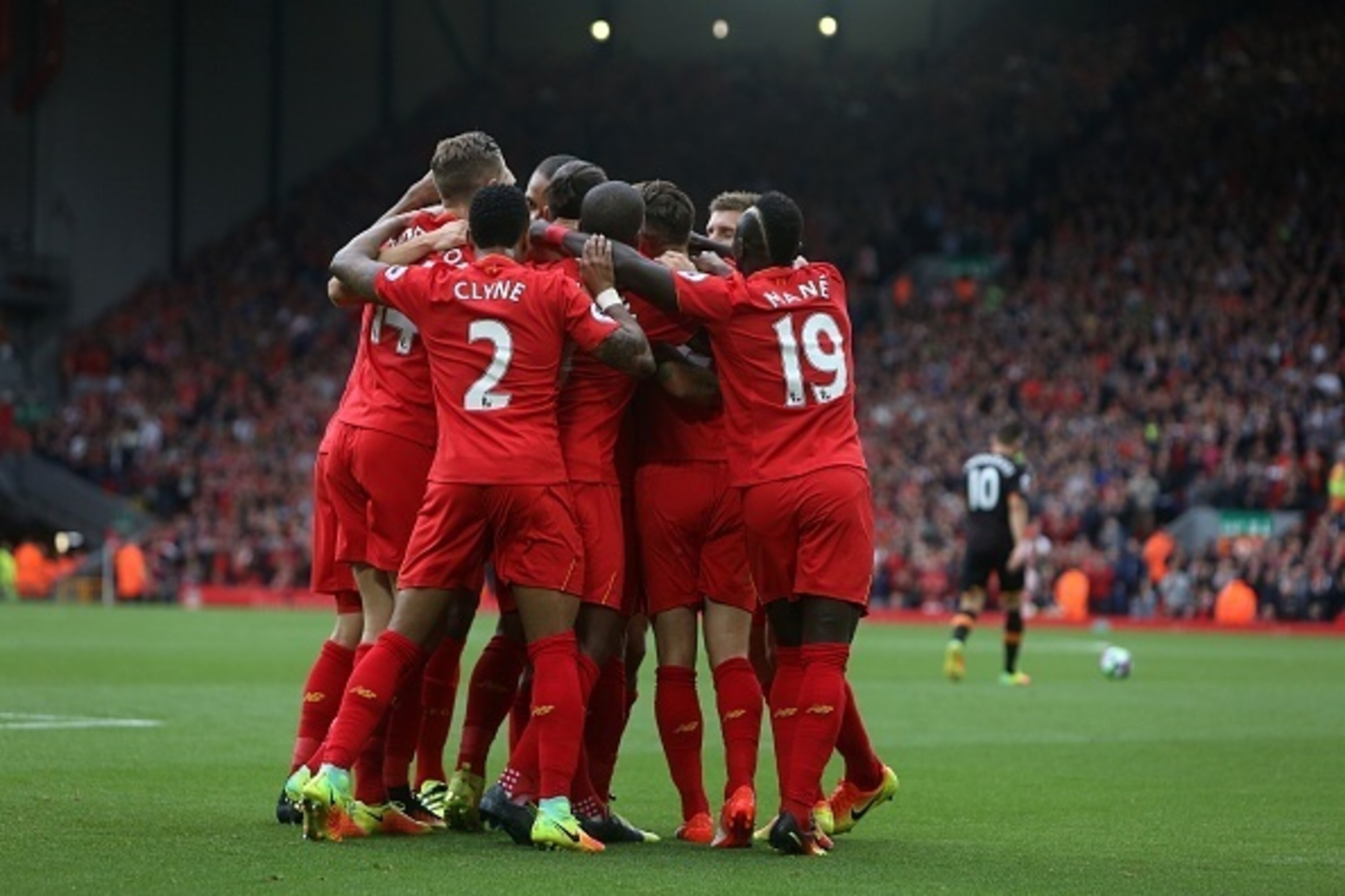 Liverpool's English midfielder Adam Lallana (unseen) is mobbed by teammates after scoring his team's first goal during the English Premier League football match between Liverpool and Hull City at Anfield in Liverpool, north west England on September 24, 2