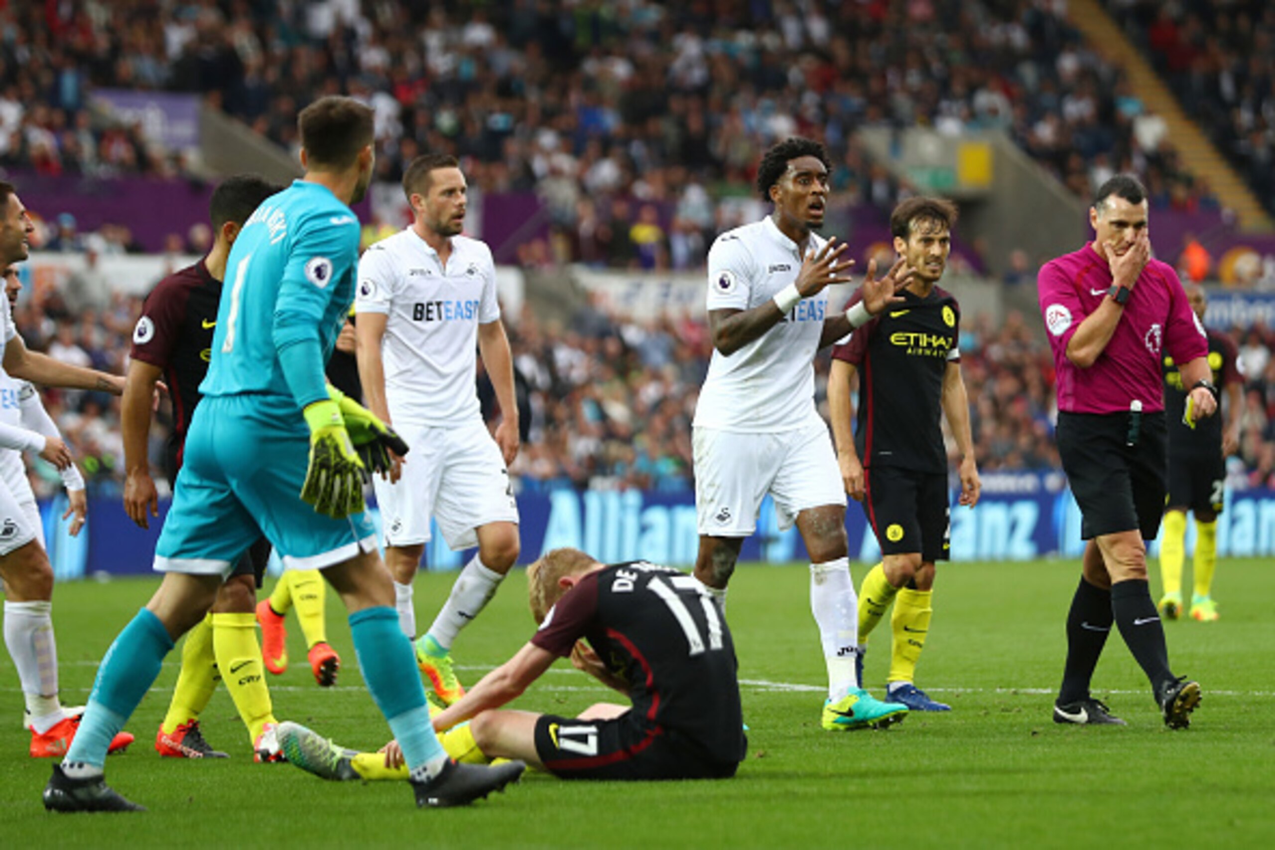 SWANSEA, WALES - SEPTEMBER 24: Leroy Fer of Swansea City (C) argues with referee Neil Swarbrick after he awarded Manchester City a penalty for a foul on Kevin De Bruyne of Manchester City  during the Premier League match between Swansea City and Mancheste