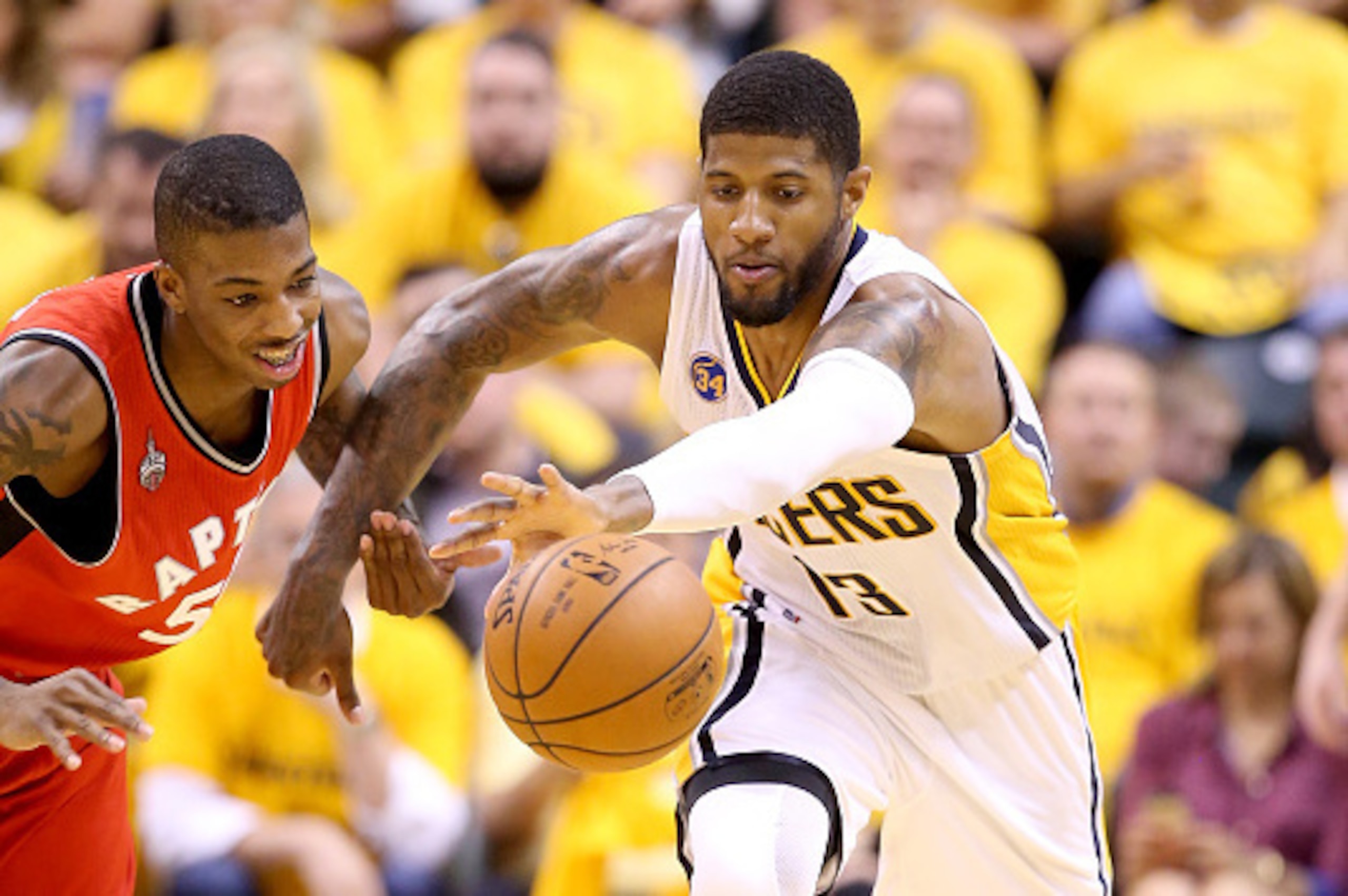 INDIANAPOLIS, IN - APRIL 29:  Paul George #13 of the Indiana Pacers battles for a loose ball with Delon Wright #55 of the Toronto Raptors in game six of the 2016 NBA Playoffs Eastern Conference Quarterfinals on April 29, 2016 in Indianapolis, Indiana.  NO