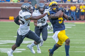 DETROIT, MI - SEPTEMBER 10: Linebacker Jabrill Peppers #5 of the Michigan Wolverines run with the football in front of defensive back Kyle Gibson #25 of the UCF Knights during a college football game at Michigan Stadium on September 10, 2016 in Ann Arbor,
