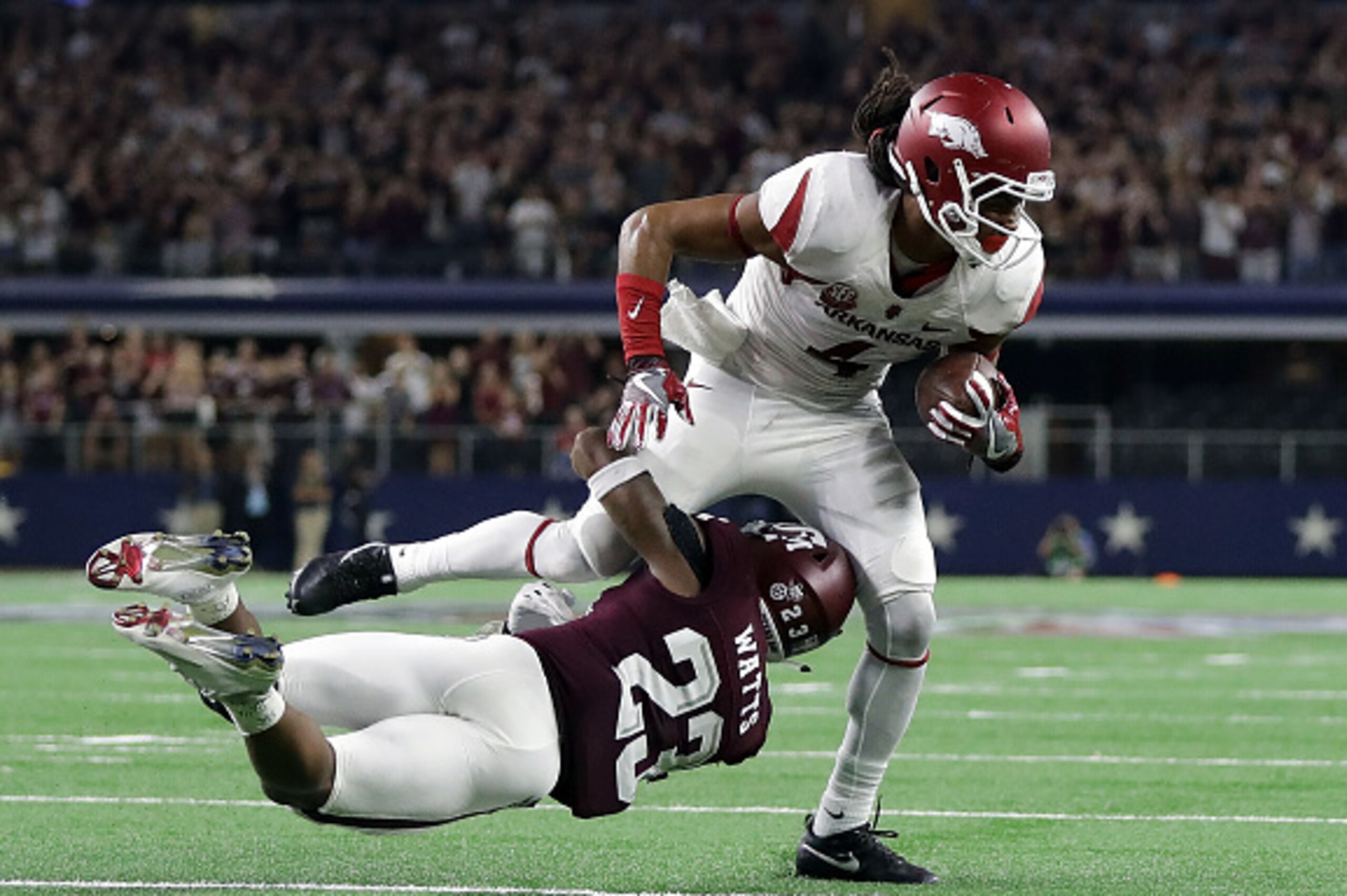 ARLINGTON, TX - SEPTEMBER 24:  Keon Hatcher #4 of the Arkansas Razorbacks is tackled by Armani Watts #23 of the Texas A&M Aggies on fourth and one in the third quarter at AT&T Stadium on September 24, 2016 in Arlington, Texas.  (Photo by Ronald Martinez/G