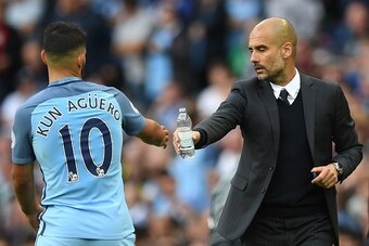 Manchester City's Spanish manager Pep Guardiola (R) hands Manchester City's Argentinian striker Sergio Aguero (L) a water bottle during the English Premier League football match between Manchester City and Sunderland at the Etihad Stadium in Manchester, n