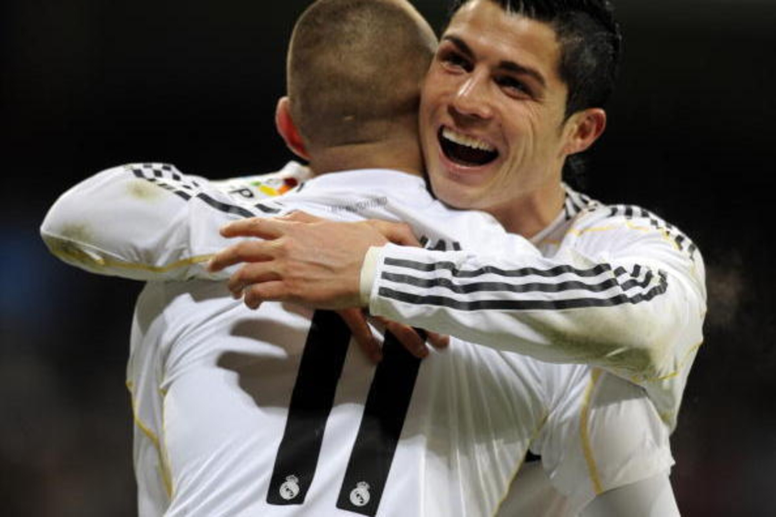 Real Madrid's French forward Karim Benzema is congratulated by Real Madrid's Portuguese forward Cristiano Ronaldo (R)  after scoring  during the Spanish league football match Real Madrid against Zaragoza at the Santiago Bernabeu stadium in Madrid, on Dece