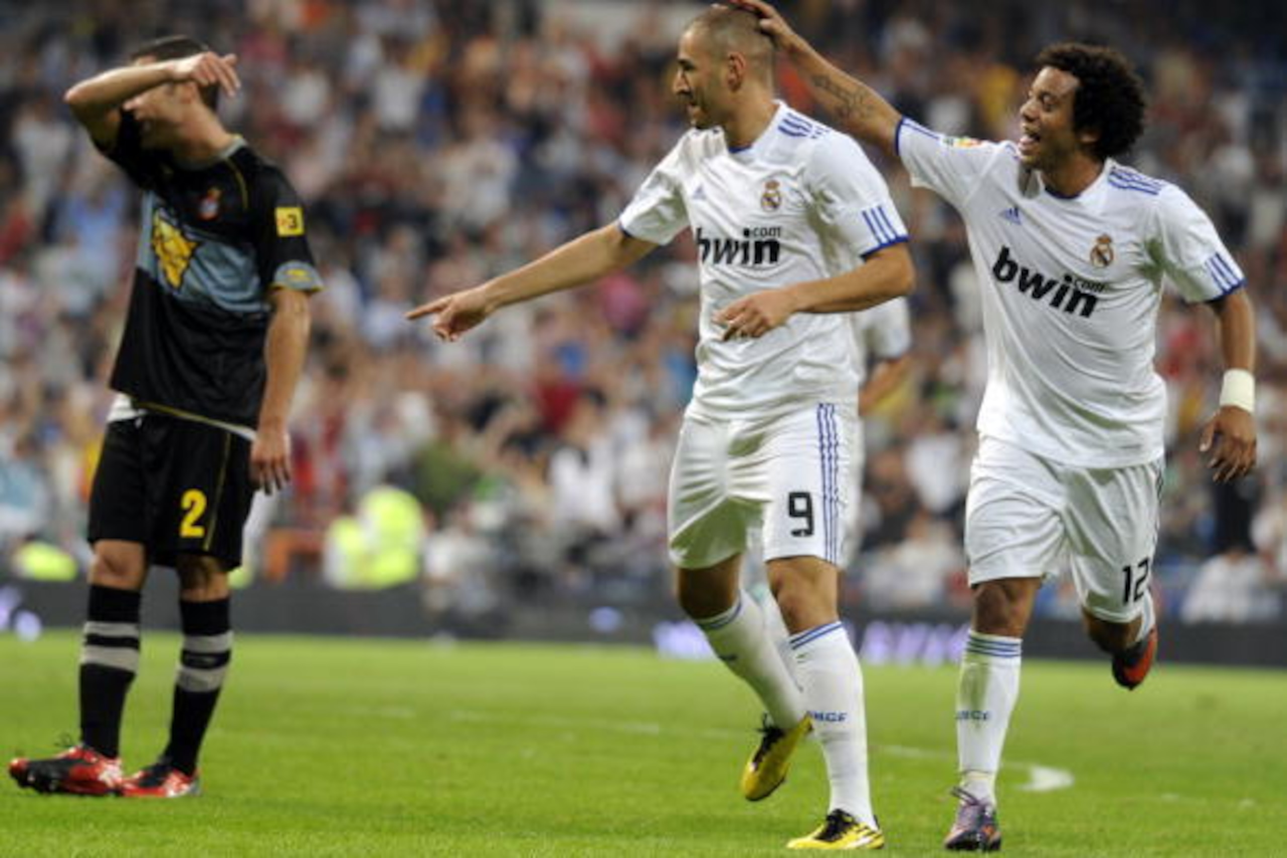 Real Madrid's French forward Karim Benzema (C) celebrates with teammate Real Madrid's Brazilian defender Marcelo (R) after scoring during the Spanish league football match Real Madrid against Espanyol at the Santiago Bernabeu stadium in Madrid, on Septemb