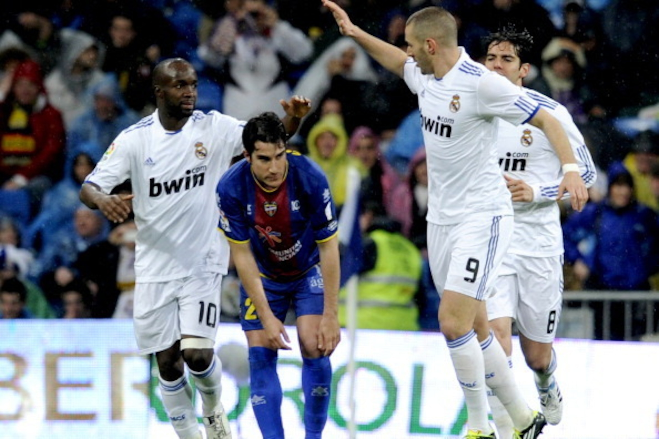 Real Madrid's French midfielder Lassana Diarra (L) and Real Madrid's French forward Karim Benzema (R), on either side of Levante's Cerra (C), react after scoring during their Spanish League football match on February 19, 2011 at the Santiago Bernabeu Stad