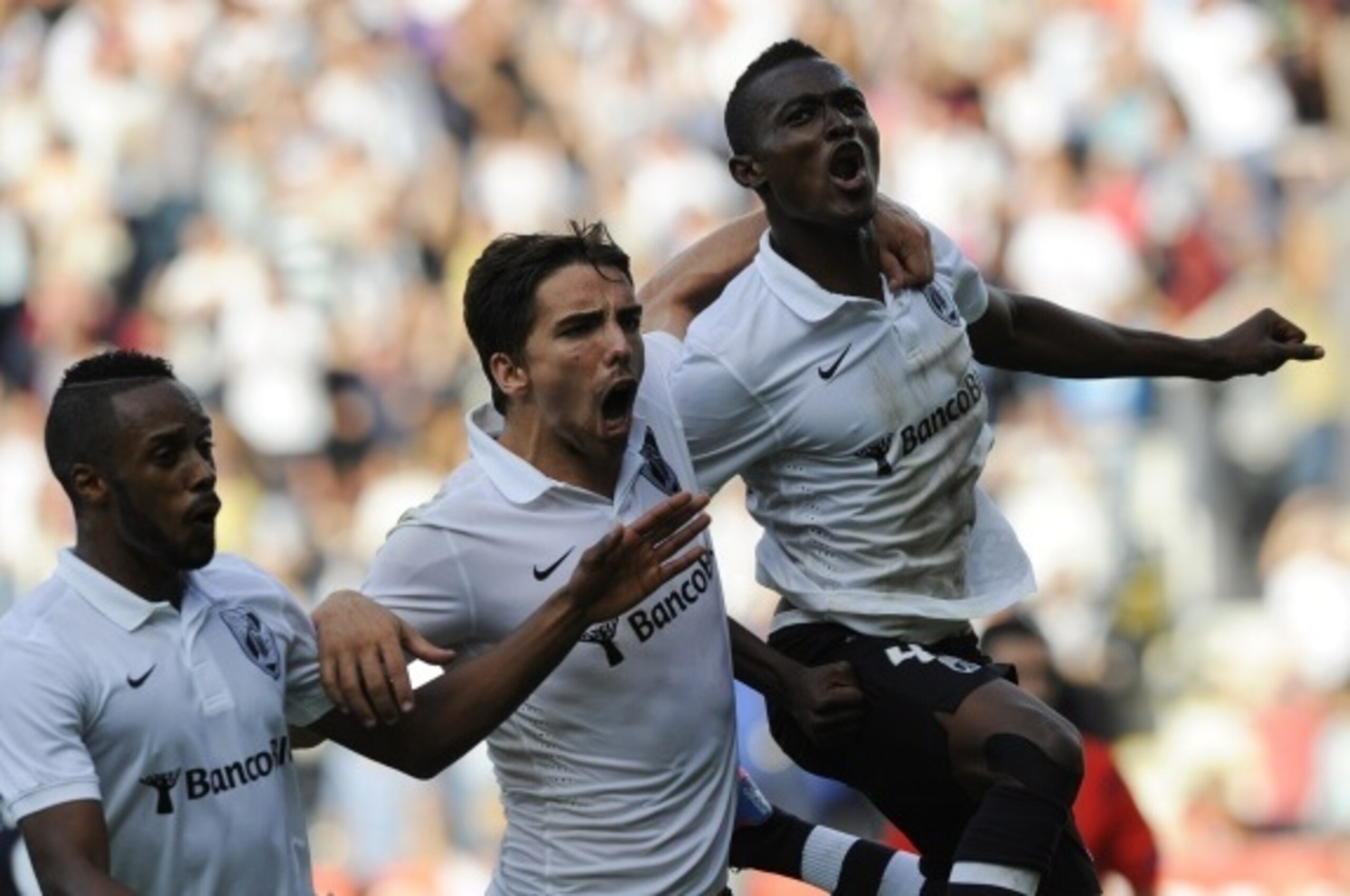 Vitoria SC's Ghanaian midfielder Bernard Mensah (R) celebrates with his teammates forward Tomane (C) and Cape Verdean forward Hernanihis after scoring during the Portuguese league football match Vitoria SC vs FC Porto at the Afonso Henriques Stadium in Gu