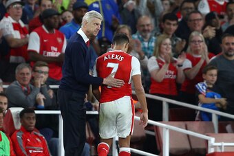 LONDON, ENGLAND - SEPTEMBER 24: Arsene Wenger, Manager of Arsenal pats Alexis Sanchez of Arsenal on the back after he is subbed during the Premier League match between Arsenal and Chelsea at the Emirates Stadium on September 24, 2016 in London, England.  