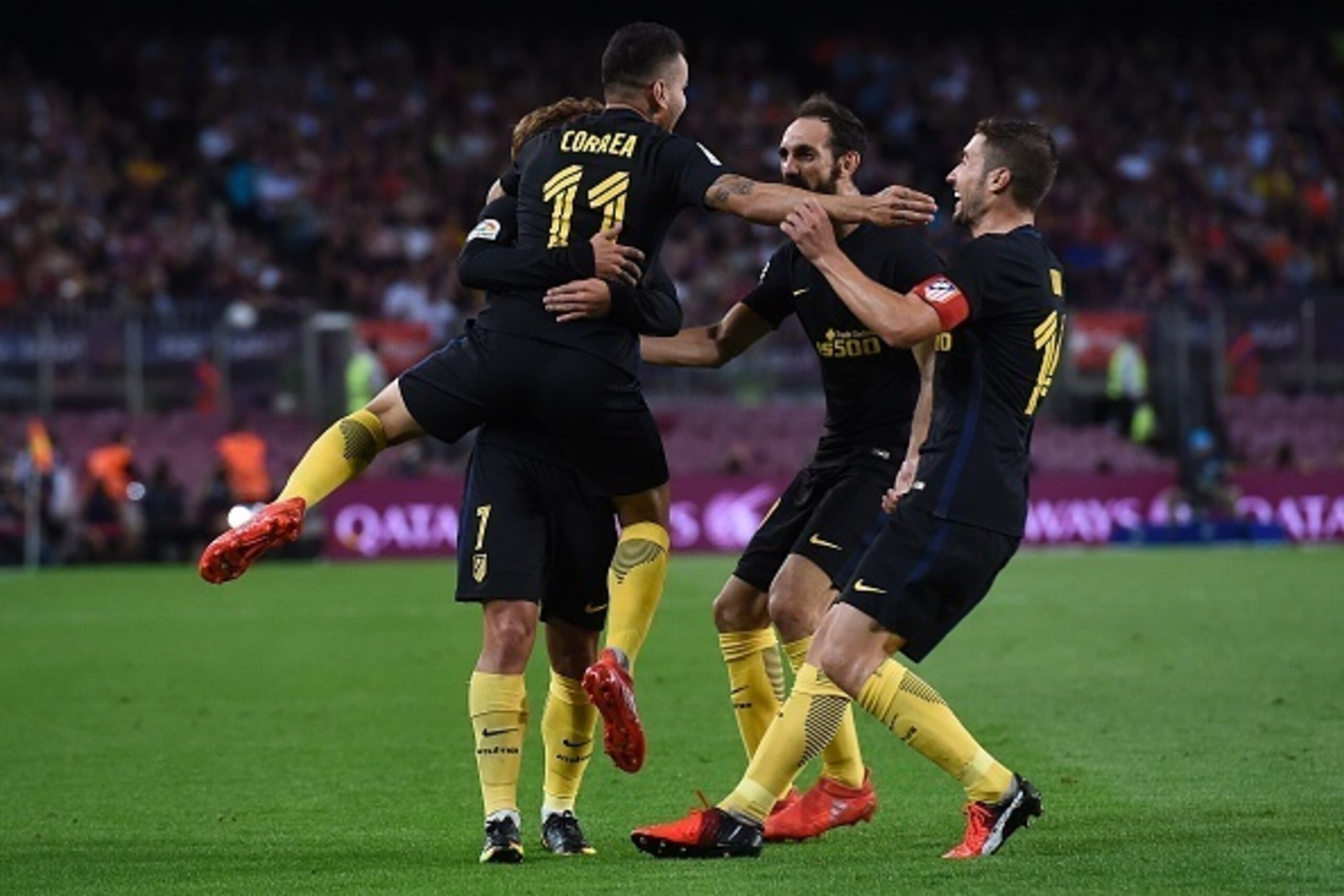 Atletico Madrid's Argentinian forward Angel Correa (L) is congratulated by teammates after scoring a goal during the Spanish league football match FC Barcelona vs Atletico de Madrid at the Camp Nou stadium in Barcelona on September 21, 2016. / AFP / JOSEP