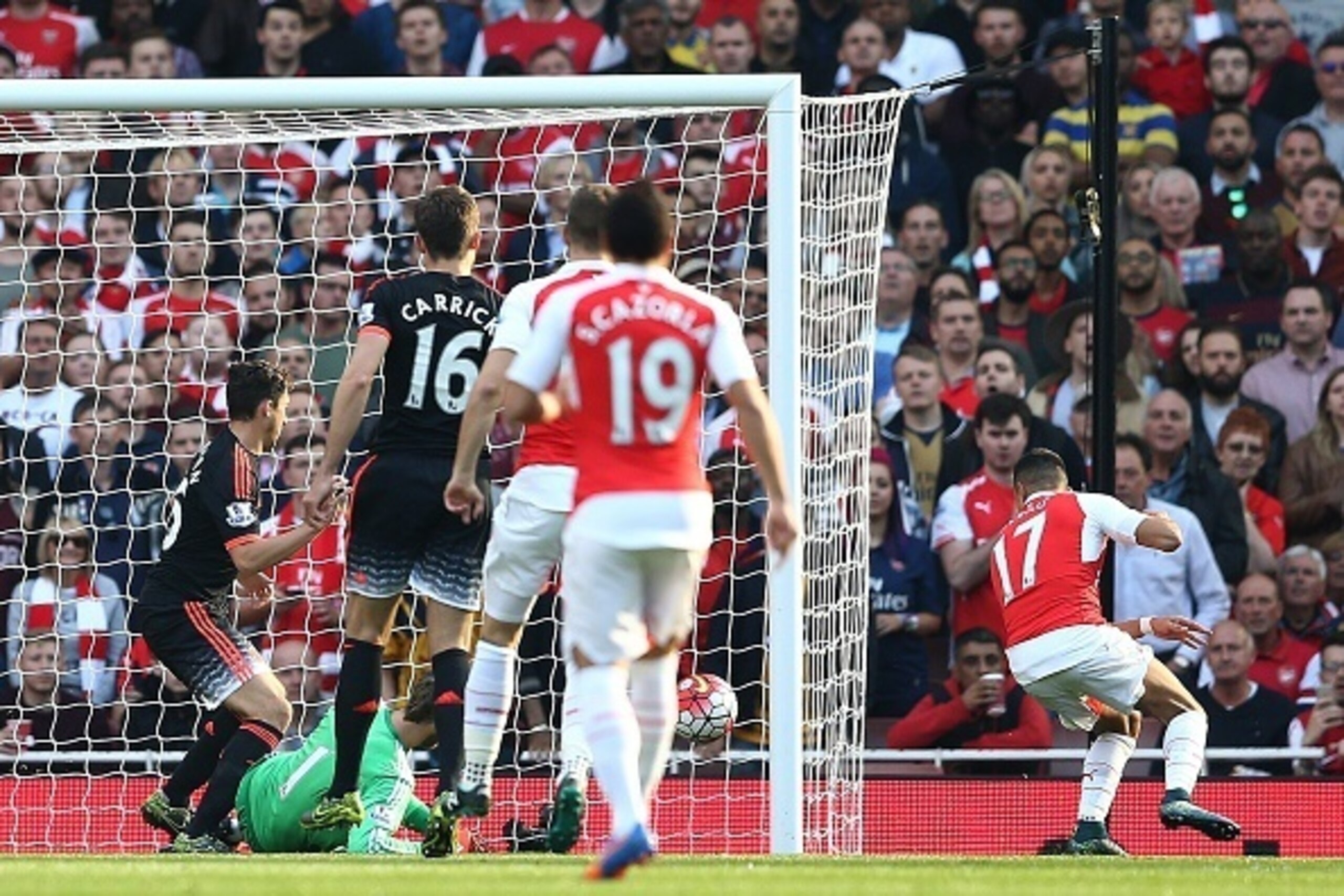 Arsenal's Chilean striker Alexis Sanchez (R) scores during the English Premier League football match between Arsenal and Manchester United at the Emirates Stadium in London on October 4, 2015.    AFP PHOTO / JUSTIN TALLIS

RESTRICTED TO EDITORIAL USE. No 