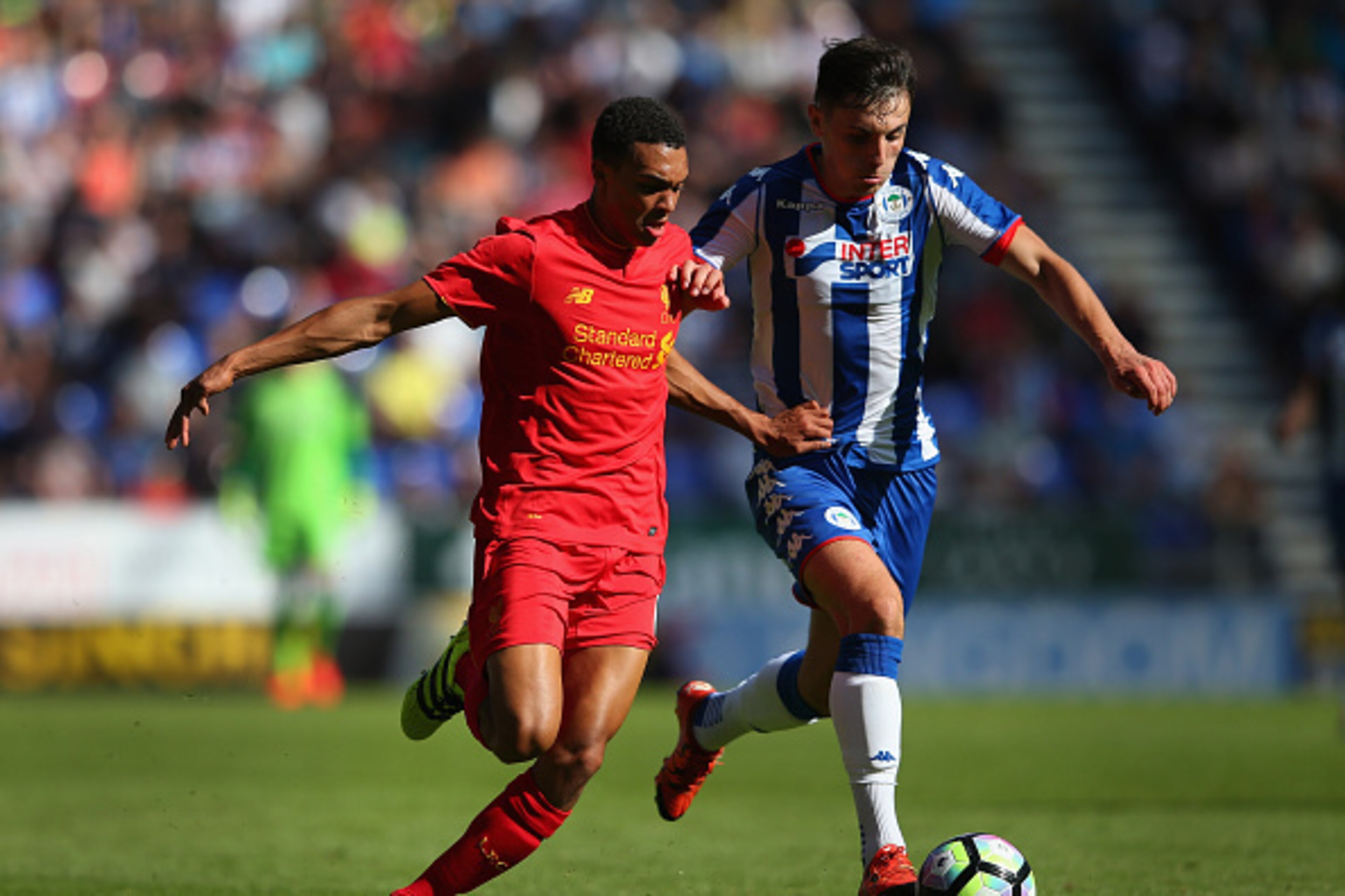 WIGAN, ENGLAND - JULY 17: Jordan Flores of Wigan Athletic and Trent Alexander-Arnold of Liverpool compete for the ball during a pre-season friendly between Wigan Athletic and Liverpool at JJB Stadium on July 17, 2016 in Wigan, England. (Photo by Alex Li WIGAN, ENGLAND - JULY 17: Jordan Flores of Wigan Athletic and Trent Alexander-Arnold of Liverpool compete for the ball during a pre-season friendly between Wigan Athletic and Liverpool at JJB Stadium on July 17, 2016 in Wigan, England. (Photo by Alex Li