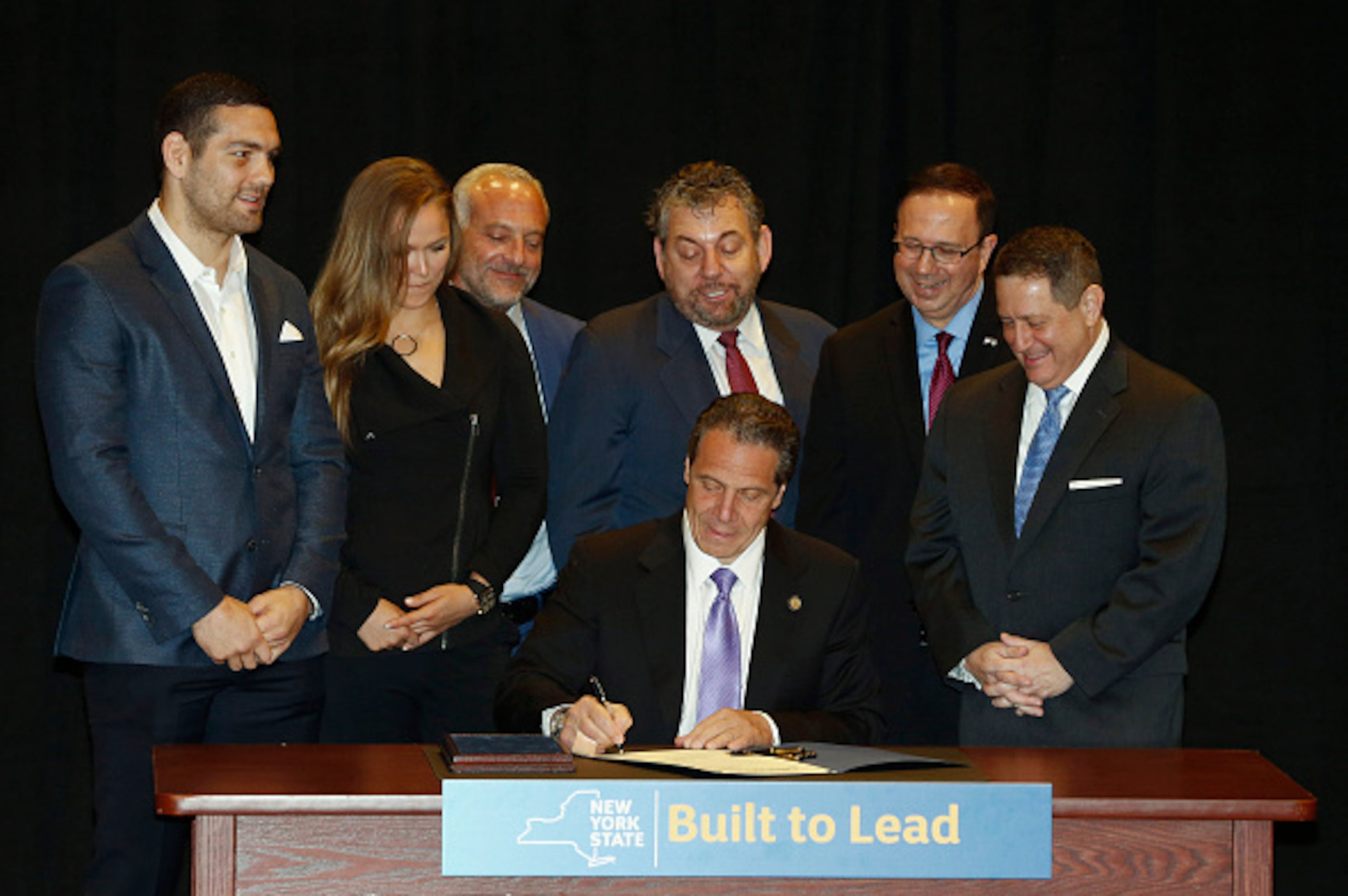 NEW YORK, NY - APRIL 14: New York Governor Andrew Cuomo is joined by (from left) UFC fighters Chris Weidman and Ronda Rousey, UFC CEO Lorenzo Fertitta, Madison Square Garden President James Dolan, Senator Joe Griffo and Assemblyman Joseph Morelle as he si