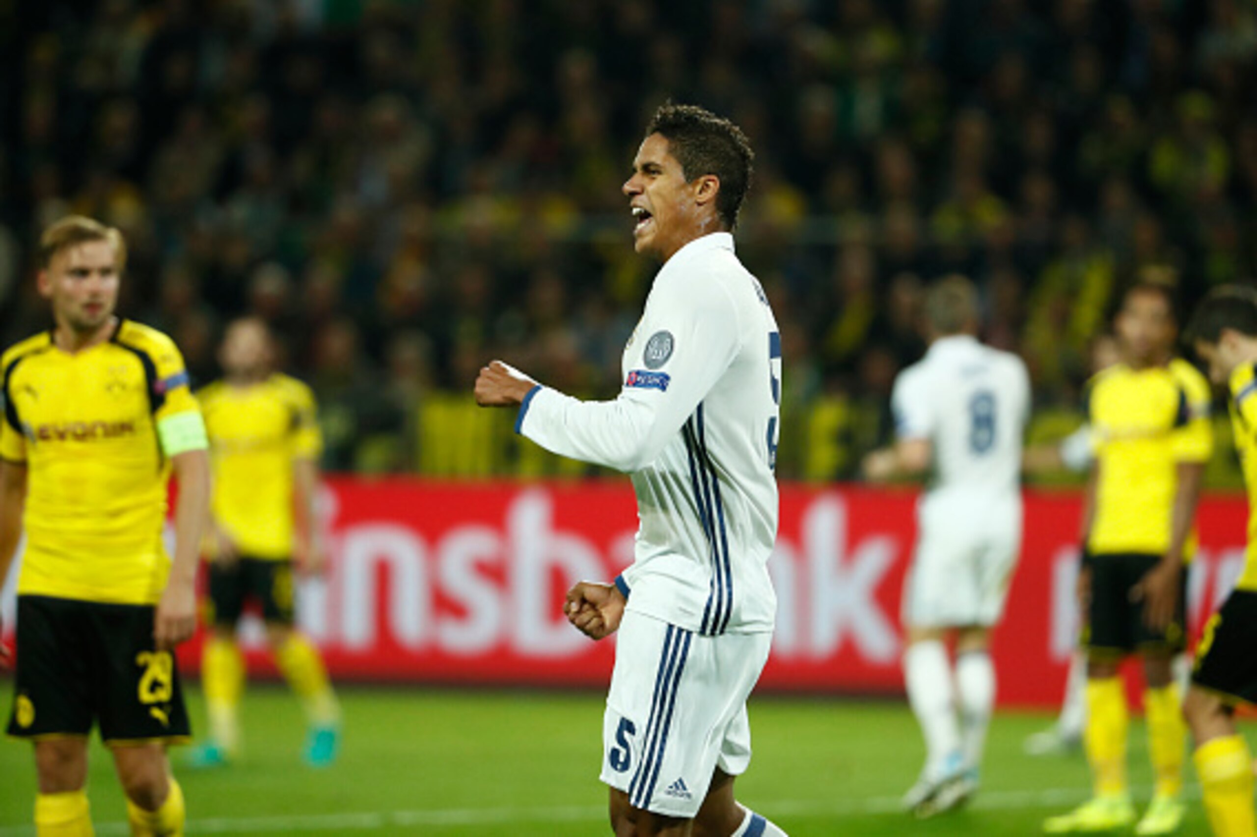 Real Madrid's French defender Raphael Varane (c) reacts after scoring during the UEFA Champions League first leg football match between Borussia Dortmund and Real Madrid at BVB stadium in Dortmund, on September 27, 2016. / AFP / Odd ANDERSEN        (Photo