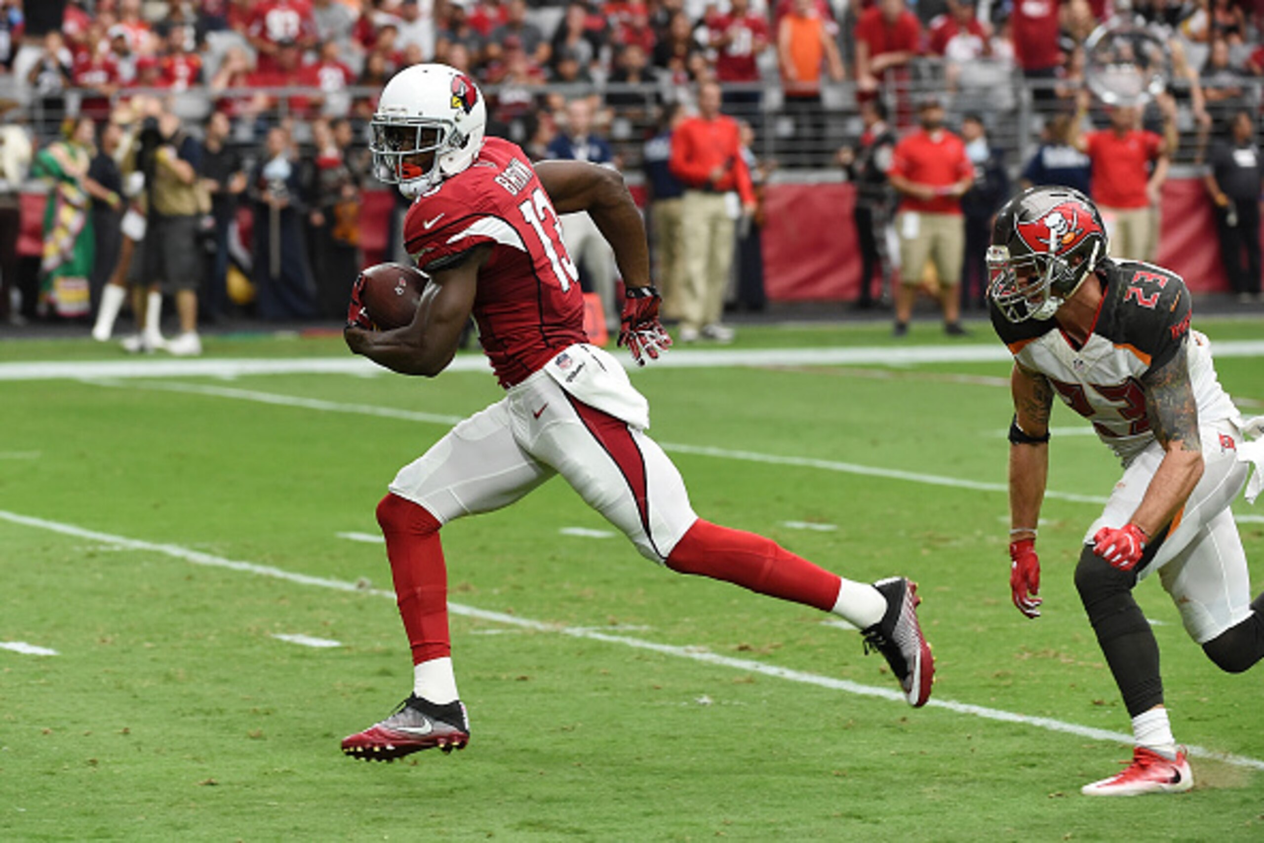 GLENDALE, AZ - SEPTEMBER 18:  Wide receiver Jaron Brown #13 of the Arizona Cardinals slips past safety Chris Conte #23 of the Tampa Bay Buccaneers for a touchdown during the second quarter of the NFL game at University of Phoenix Stadium on September 18, 