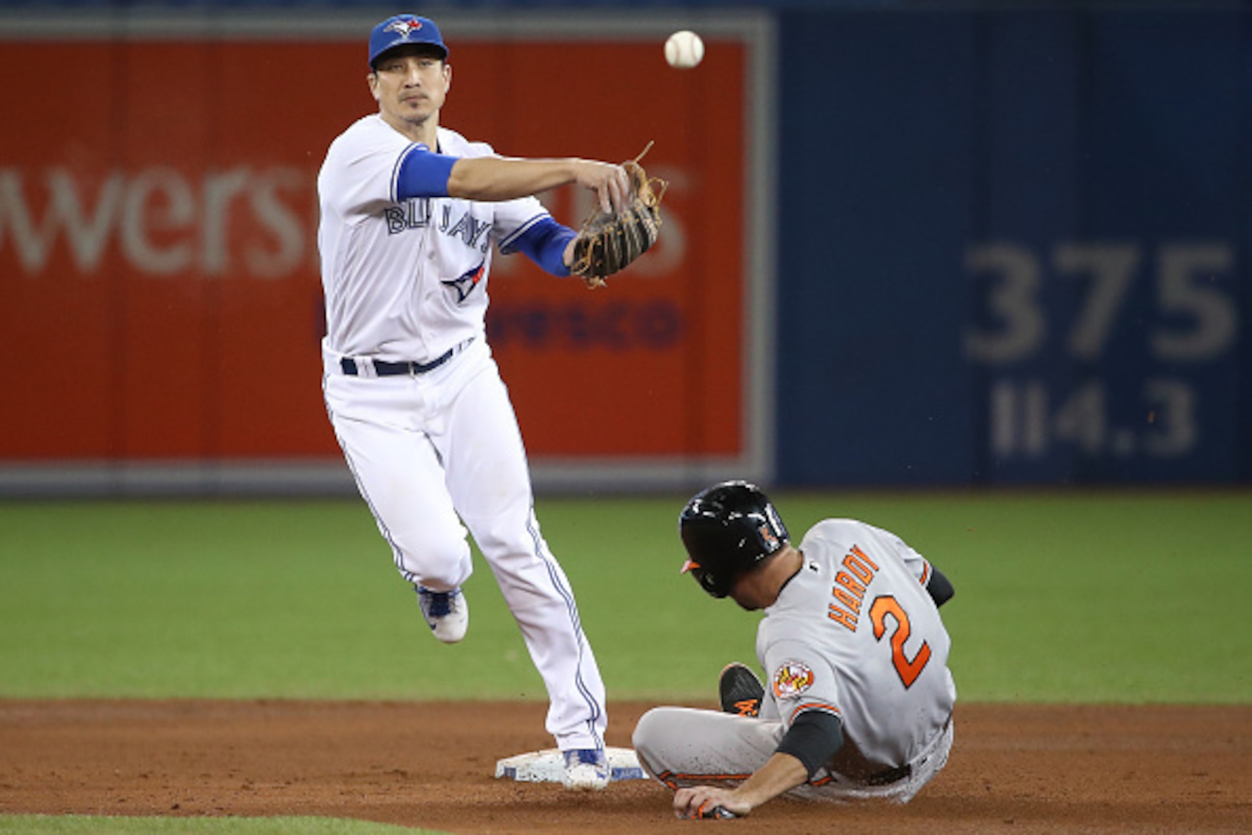 TORONTO, CANADA - SEPTEMBER 27: Darwin Barney #41 of the Toronto Blue Jays turns a double play in the first inning to end the game during MLB game action as J.J. Hardy #2 of the Baltimore Orioles slides into second base on September 27, 2016 at Rogers Cen