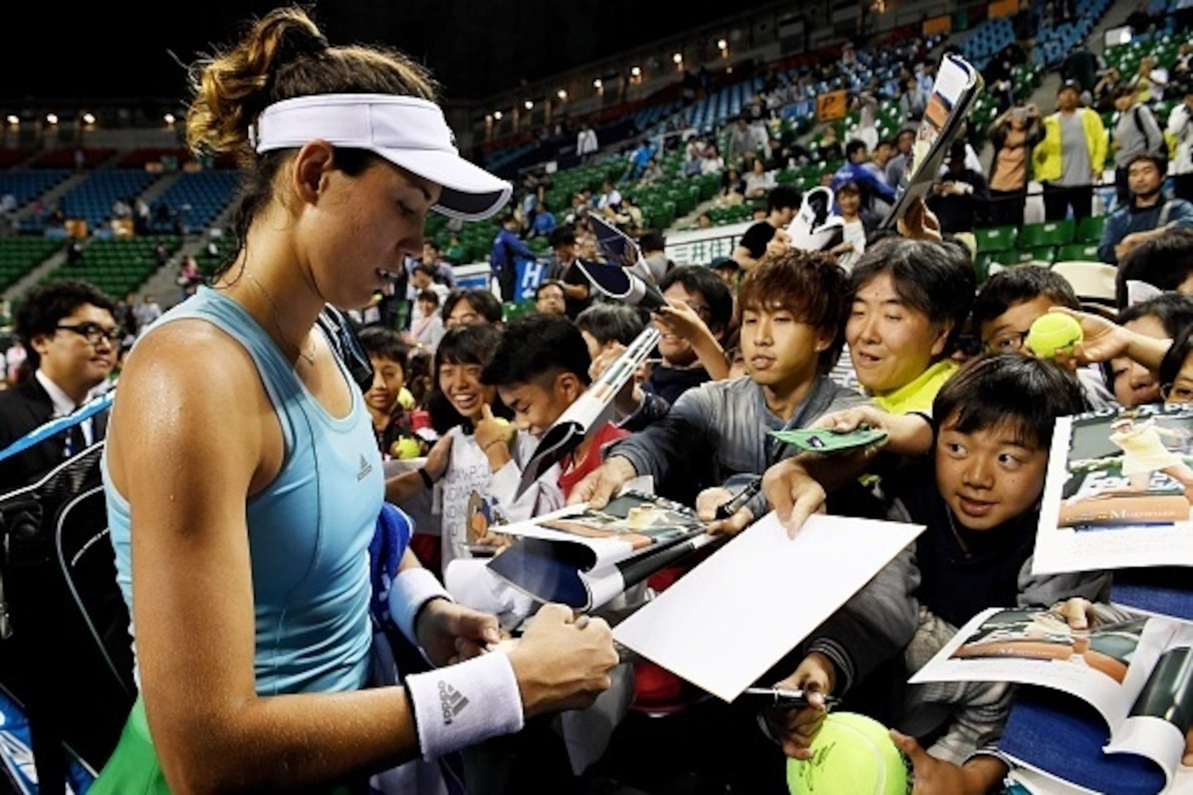 Garbine Muguruza of Spain signs autographs after her victory against Anastasija Sevastova of Latvia in their women's singles second round match at the WTA Pan Pacific Open tennis tournament in Tokyo on September 22, 2016. / AFP / TOSHIFUMI KITAMURA       