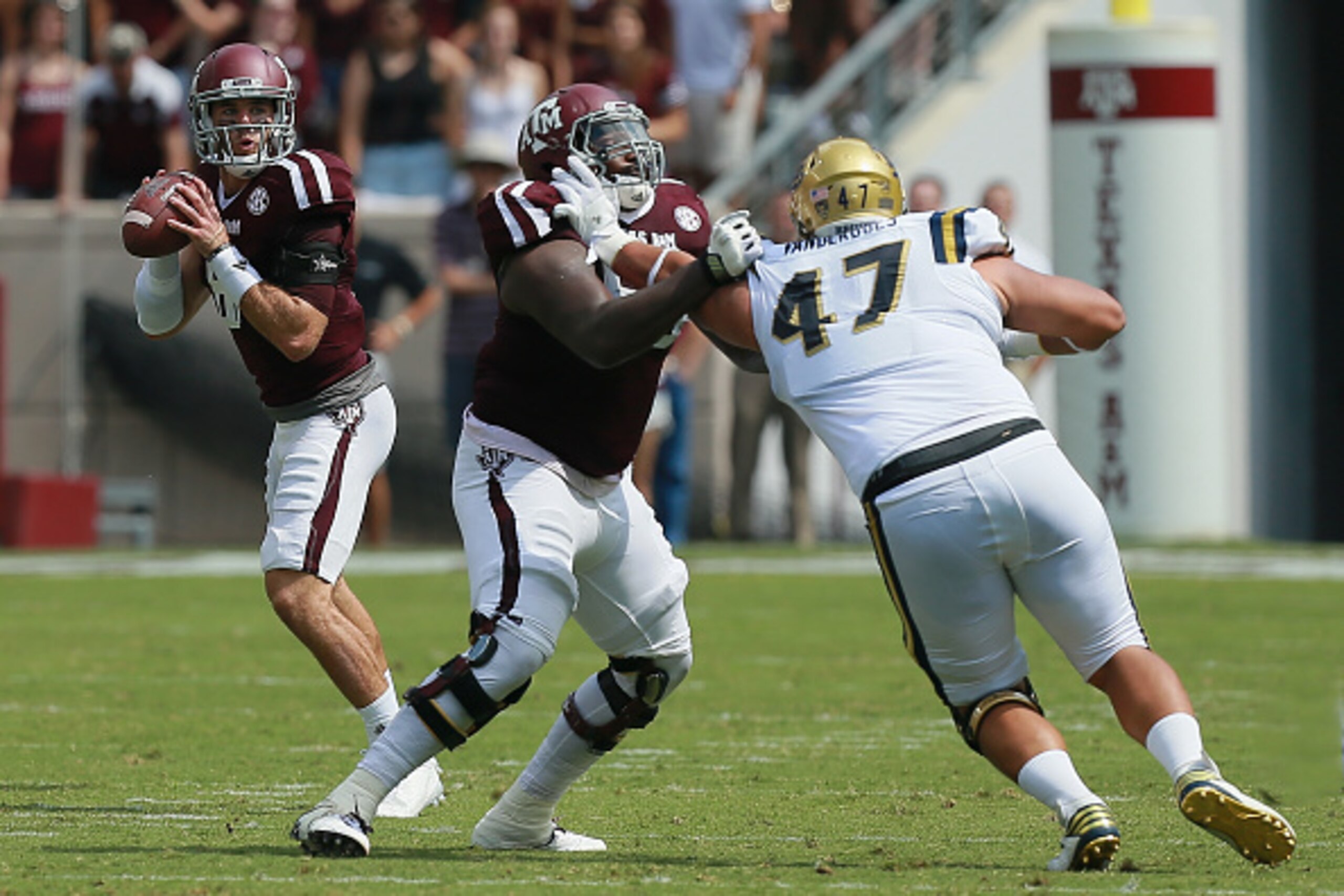 COLLEGE STATION, TX - SEPTEMBER 03: Trevor Knight #8 of the Texas A&M Aggies drops back in the pocket as he receives protection from Avery Gennesy #65 who blocks Eddie Vanderdoes #47 of the UCLA Bruins on September 3, 2016 in College Station, Texas. (Phot