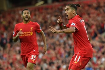 Liverpool's Brazilian midfielder Roberto Firmino (R) celebrates after scoring their fourth goal during the English Premier League football match between Liverpool and Leicester City at Anfield in Liverpool, north west England on September 10, 2016. / AFP 