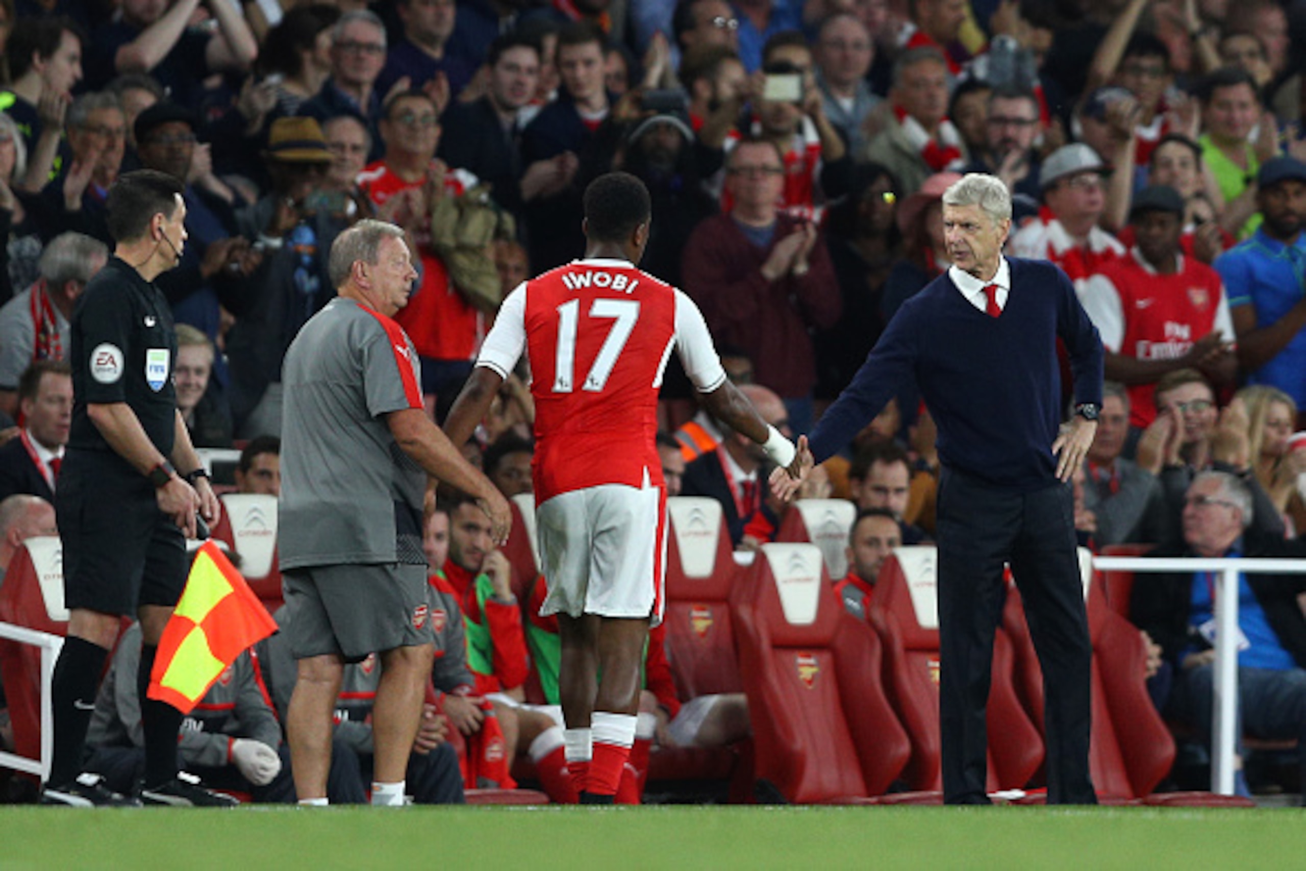 LONDON, ENGLAND - SEPTEMBER 24: Alex Iwobi of Arsenal (L) and Arsene Wenger, Manager of Arsenal (R) shake hands after he is subbed during the Premier League match between Arsenal and Chelsea at the Emirates Stadium on September 24, 2016 in London, England