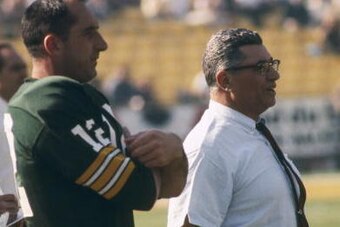 Green Bay Packers Hall of Fame head coach Vince Lombardi adn backup quarterback Zeke Bratkowski (12) watch the team warm up before Super Bowl I, a 35-10 victory over the Kansas City Chiefs on January 15, 1967, at the Los Angeles Memorial Coliseum in Los A