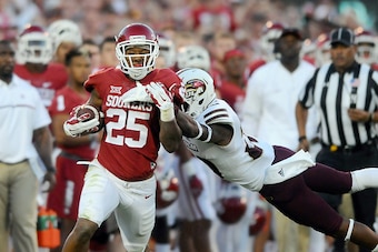 NORMAN, OK - SEPTEMBER 10: Running back Joe Mixon #25 of the Oklahoma Sooners gets tackled by safety Justin Backus #20 of the Louisiana Monroe Warhawks on Saturday September 10, 2016 at Gaylord Family Oklahoma Memorial Stadium in Norman, Oklahoma. (Photo 