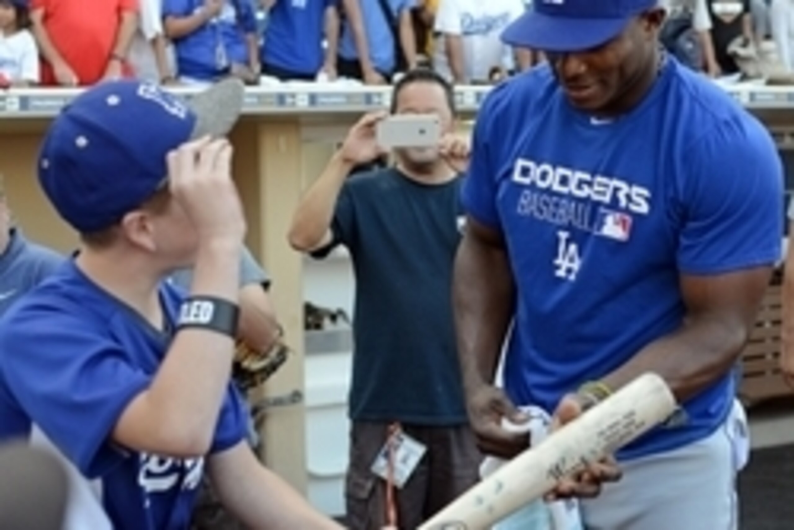 Sep 29, 2016; San Diego, CA, USA; Los Angeles Dodgers right fielder Yasiel Puig (R) hands Noah Rosenberg (L) one of his bats after Noah did push-ups for the bat before the game against the San Diego Padres at Petco Park. Puig pulled him out of the stands 
