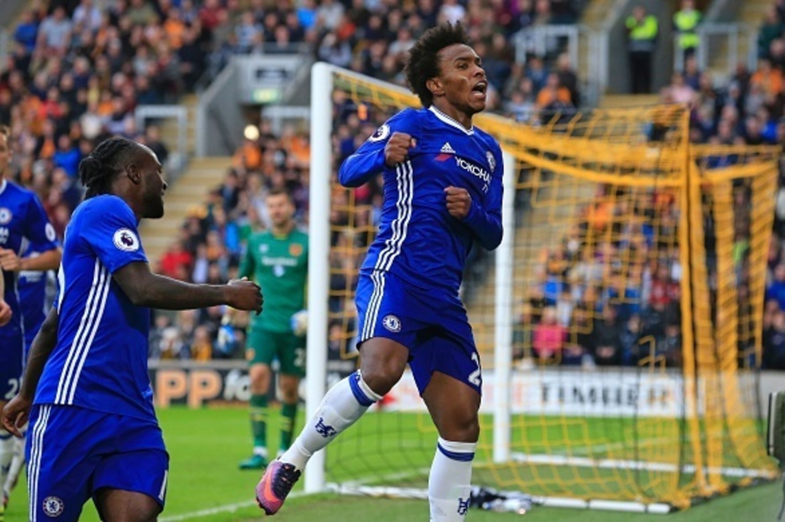 Chelsea's Brazilian midfielder Willian (R) celebrates after scoring the opening goal of the English Premier League football match between Hull City and Chelsea at the KCOM Stadium in Kingston upon Hull, north east England on October 1, 2016. / AFP / Linds