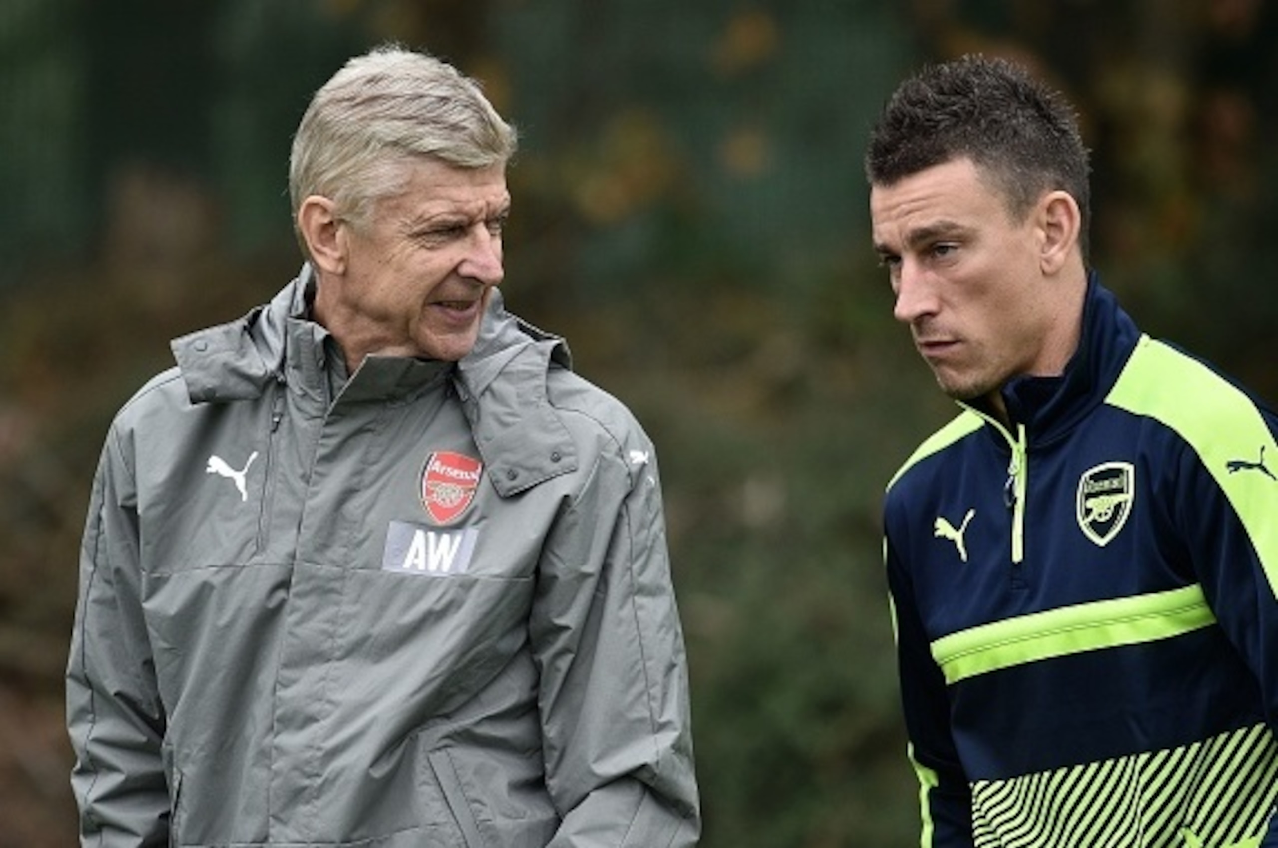 Arsenal's French manager Arsene Wenger (L) talks with Arsenal's French defender Laurent Koscielny during a team training session at Arsenal's London Colney training ground on September 27, 2016 ahead of their UEFA Champions League Group A match against Ba