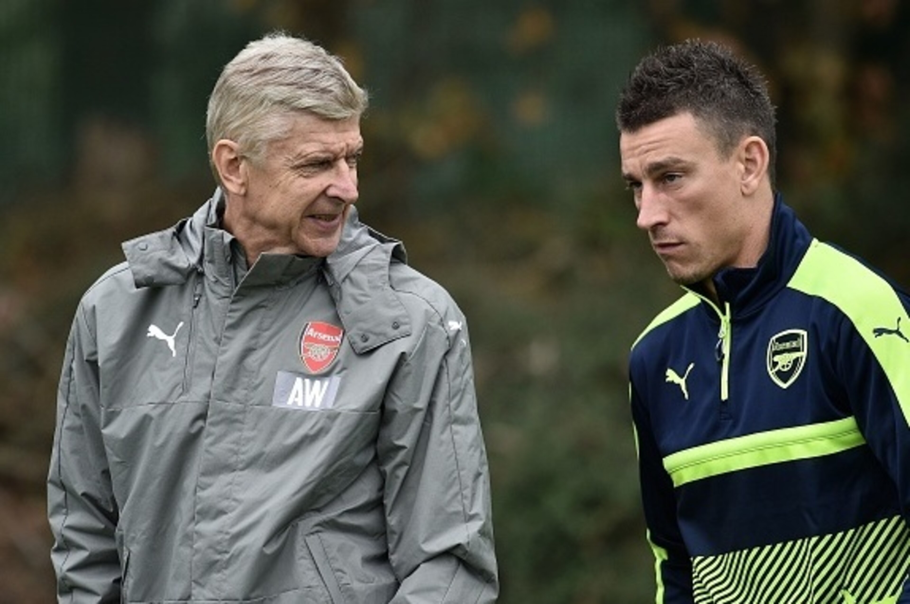 Arsenal's French manager Arsene Wenger (L) talks with Arsenal's French defender Laurent Koscielny during a team training session at Arsenal's London Colney training ground on September 27, 2016 ahead of their UEFA Champions League Group A match against Ba