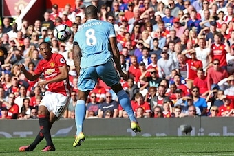 Manchester United's French striker Anthony Martial (L) shoots to score the opening goal past Stoke City's English defender Glen Johnson during the English Premier League football match between Manchester United and Stoke City at Old Trafford in Manchester