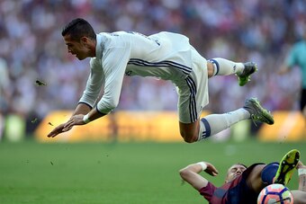 Real Madrid's Portuguese forward Cristiano Ronaldo (top) is tackled by Eibar's French defender Florian Lejeune during the Spanish league football match Real Madrid CF vs SD Eibar at the Santiago Bernabeu stadium in Madrid on October 2, 2016. / AFP / JAVIE