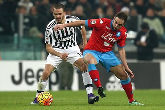 Juventus' defender Leonardo Bonucci (L) fights for the ball with Napoli's forward Gonzalo Higuain during the Italian Serie A football match Juventus vs Napoli at Juventus Stadium in Turin on February 13, 2016. / AFP / MARCO BERTORELLO        (Photo credit