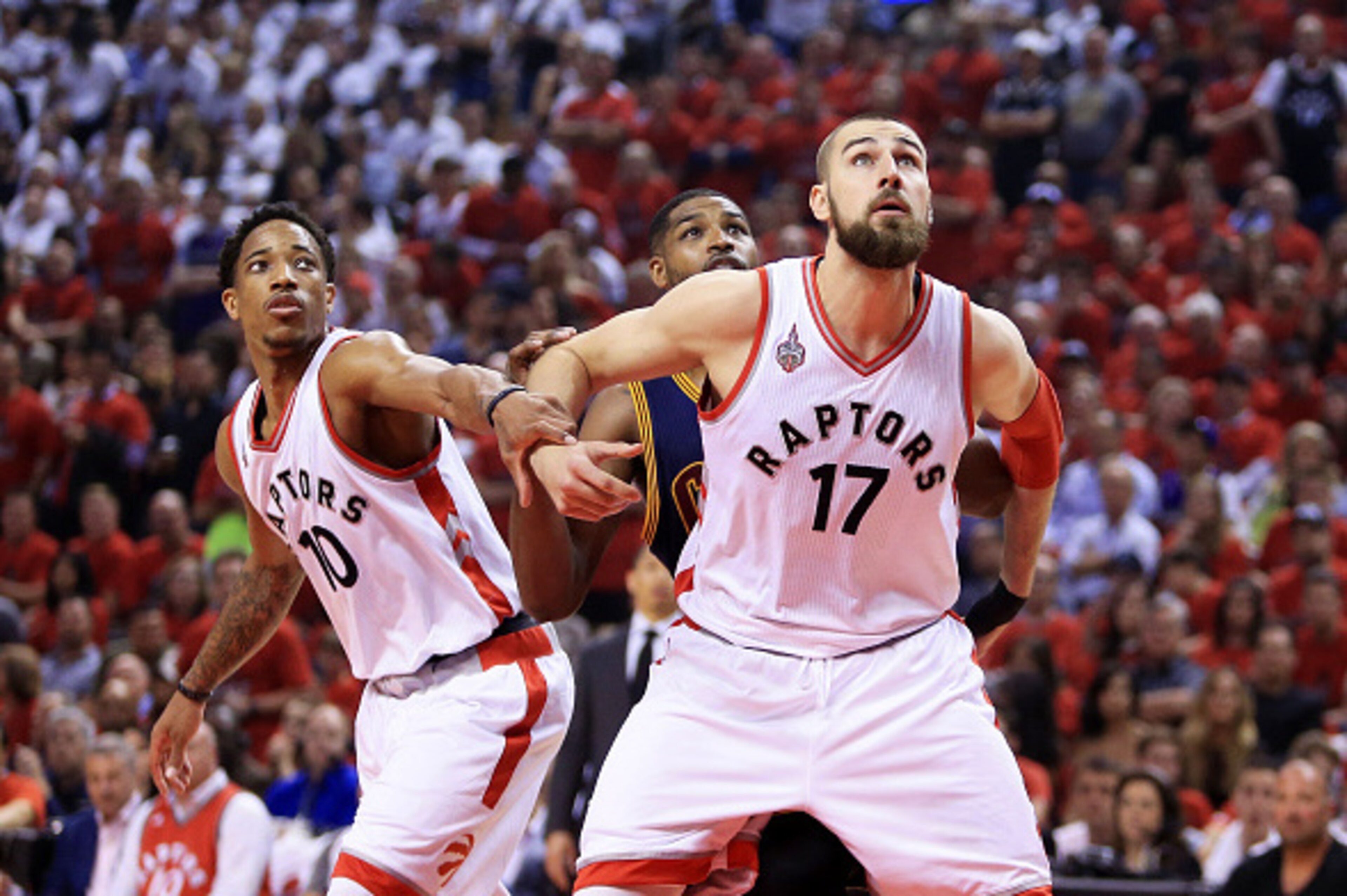 TORONTO, ON - MAY 27:  Jonas Valanciunas #17 and DeMar DeRozan #10 of the Toronto Raptors look to rebound against Tristan Thompson #13 of the Cleveland Cavaliers in the first half in game six of the Eastern Conference Finals during the 2016 NBA Playoffs a