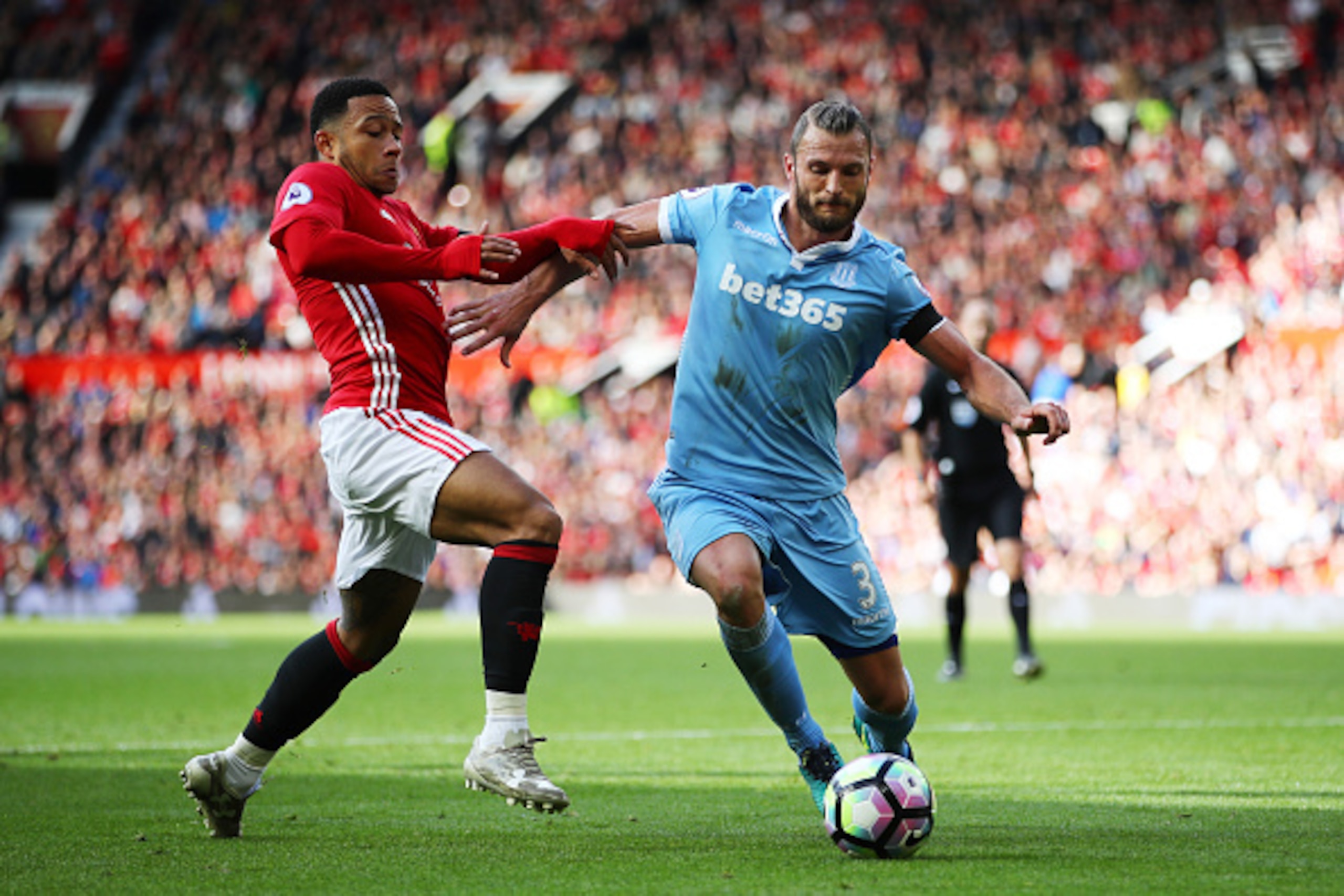 MANCHESTER, ENGLAND - OCTOBER 02: Memphis Depay of Manchester United (L) and Erik Pieters of Stoke City (R) battle for possession during the Premier League match between Manchester United and Stoke City at Old Trafford on October 2, 2016 in Manchester, En