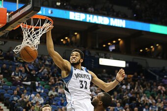 MINNEAPOLIS, MN - APRIL 13:  Karl-Anthony Towns #32 of the Minnesota Timberwolves dunks on Jordan Hamilton #25 of the New Orleans Pelicans in the second half on April 13, 2016 at Target Center in Minneapolis, Minnesota. (Photo by Adam Bettcher/Getty Image