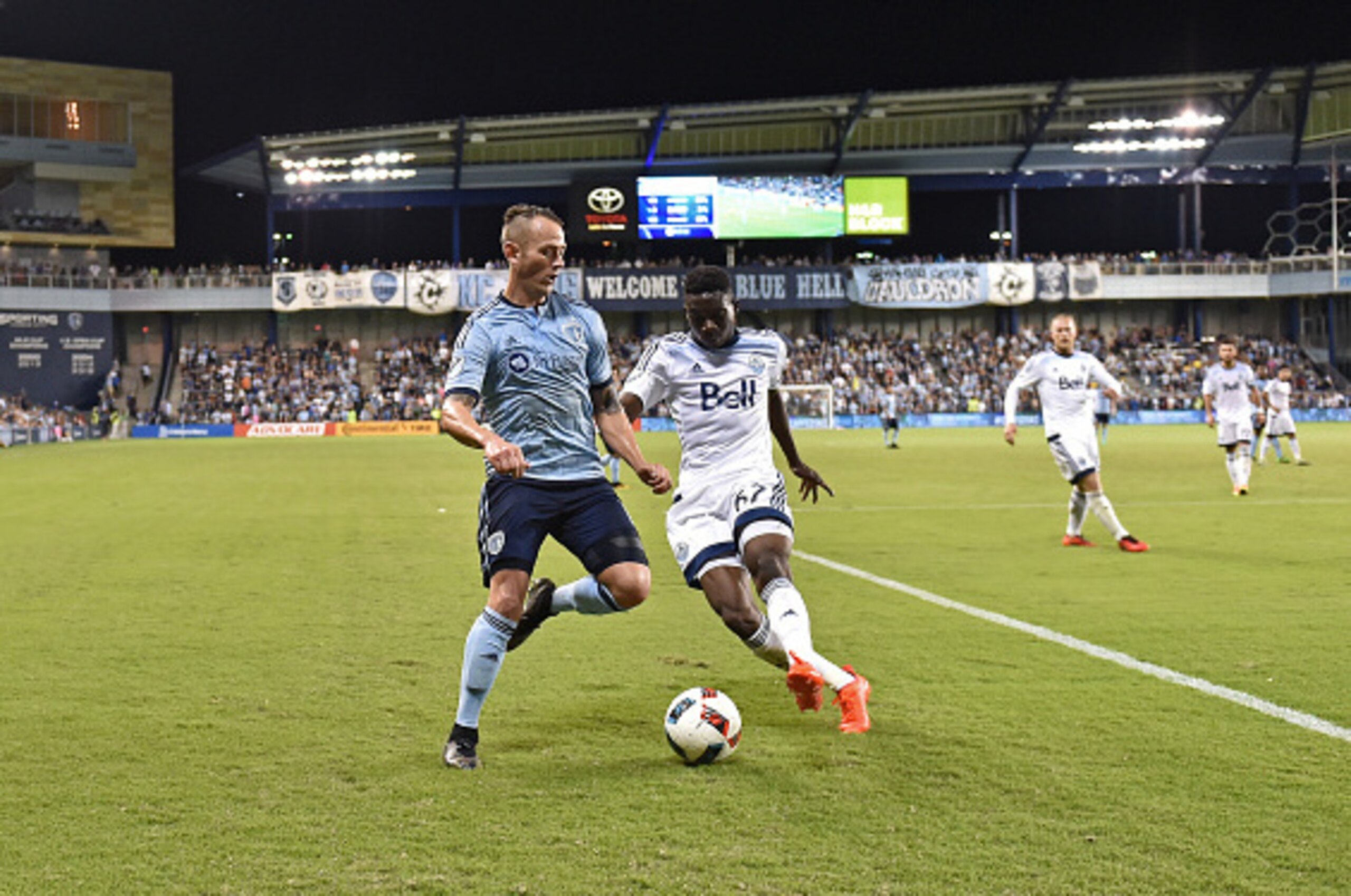 KANSAS CITY, KS - AUGUST 20:  Mid-fielder Brad Davis #11 of Sporting Kansas City dribbles the ball against defender Alphonso Davies #67 of the Vancouver Whitecaps FC during the second half on August 20, 2016 at Children's Mercy Park in Kansas City, Kansas